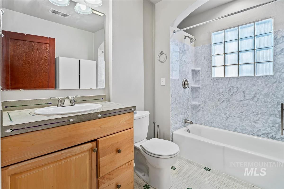 Bathroom featuring vanity, washtub / shower combination, and tile patterned floors