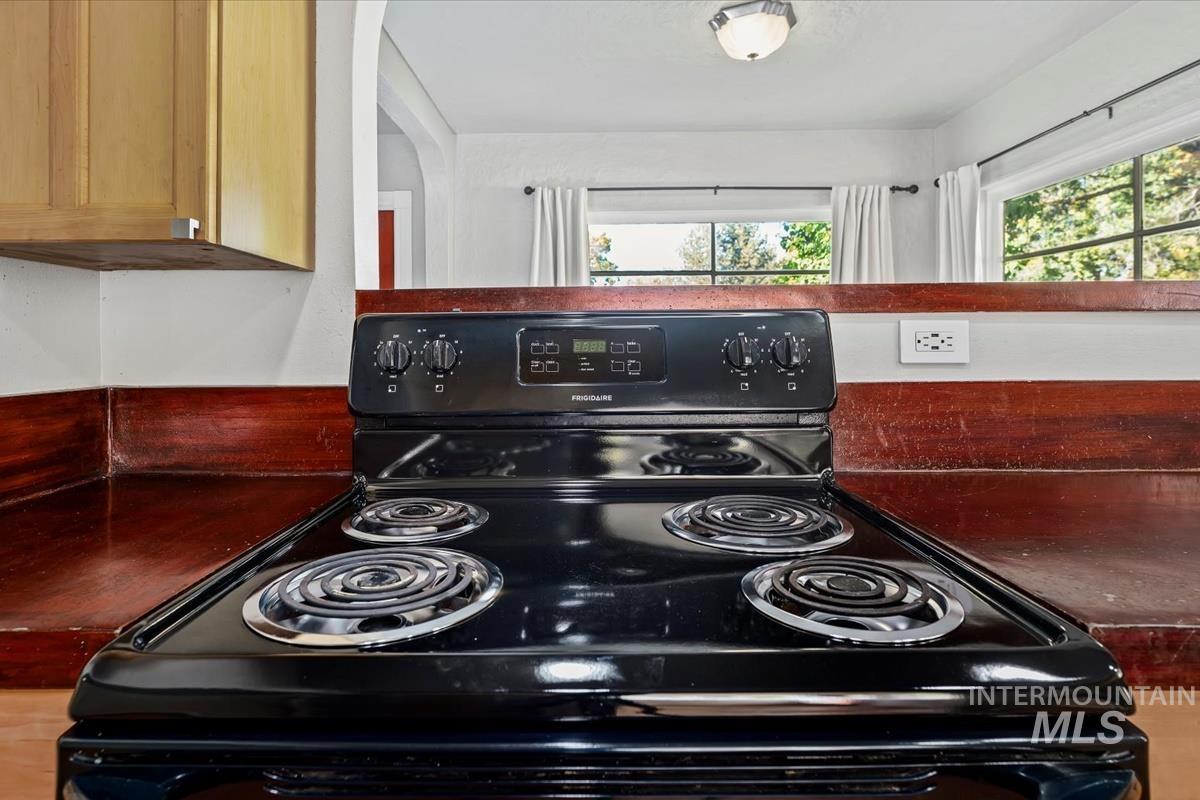 Kitchen view of black / electric stove and dark countertops