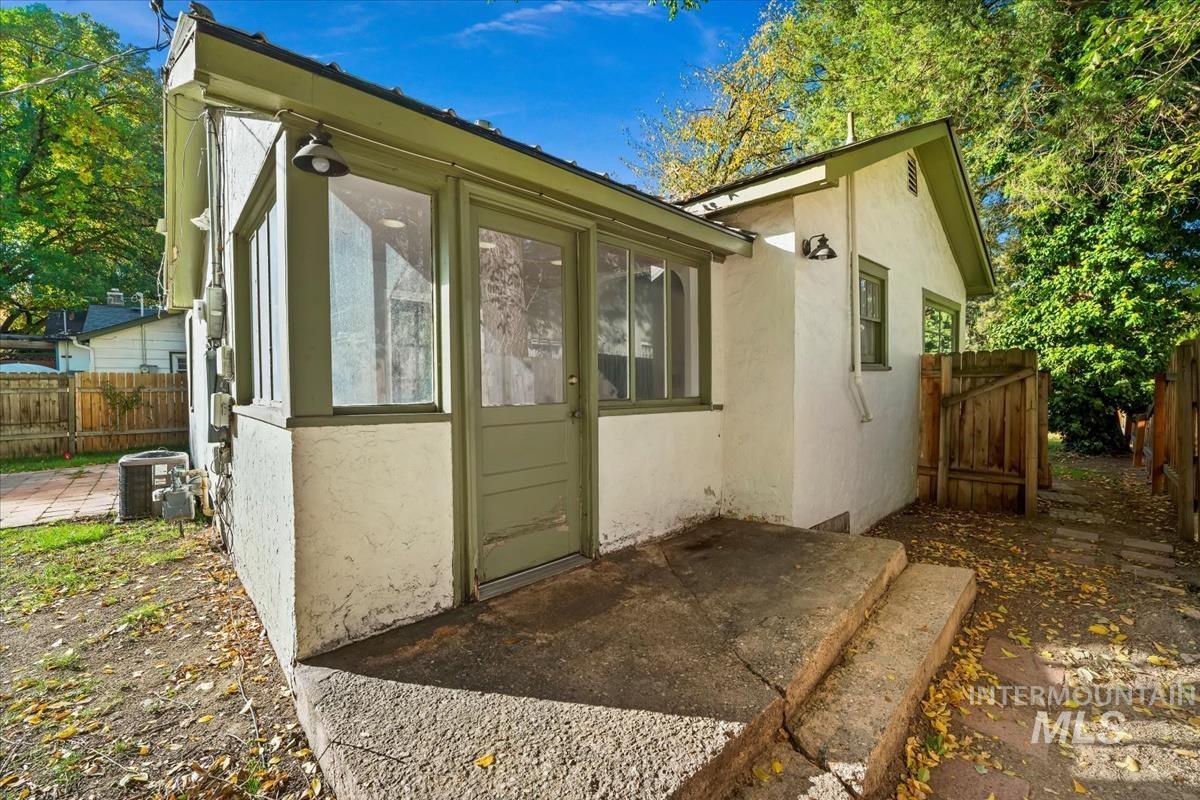 View of side of property with a patio, stucco siding, and a sunroom
