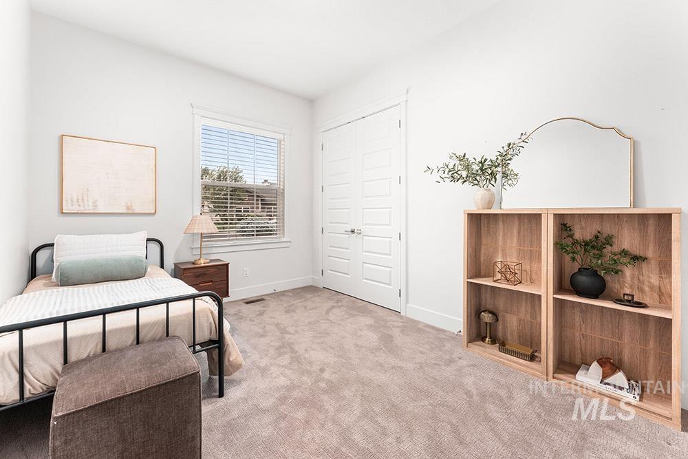 Bedroom with light colored carpet and a closet