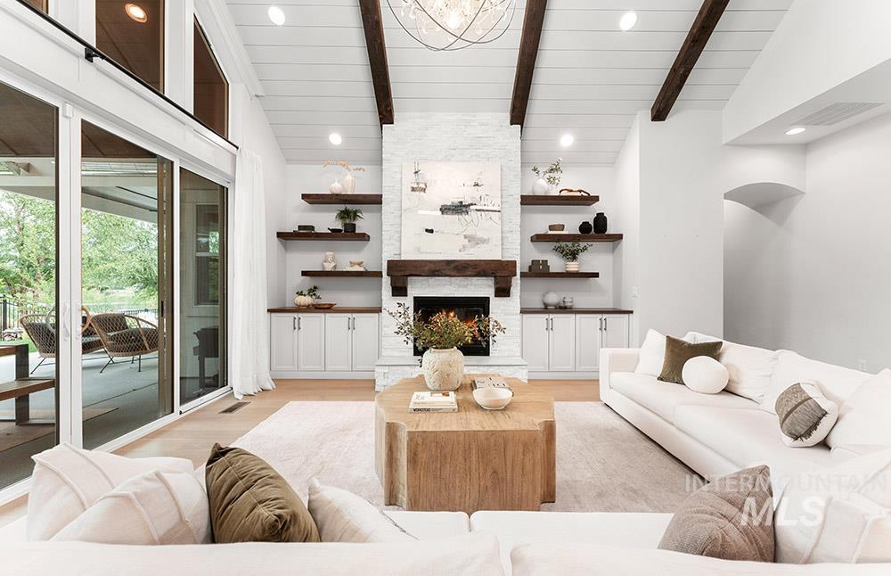 Living area featuring recessed lighting, light wood finished floors, and a stone fireplace