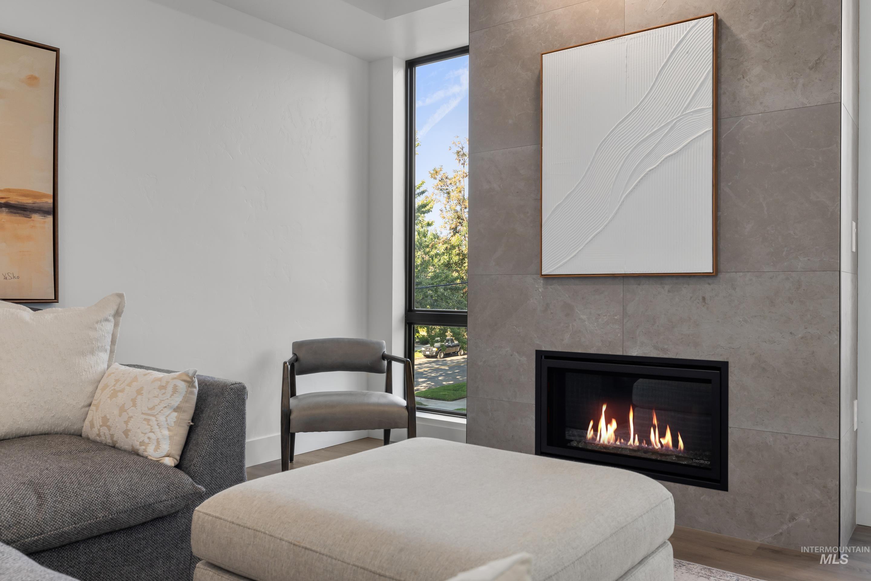 Living area featuring wood finished floors, a fireplace, and floor to ceiling windows