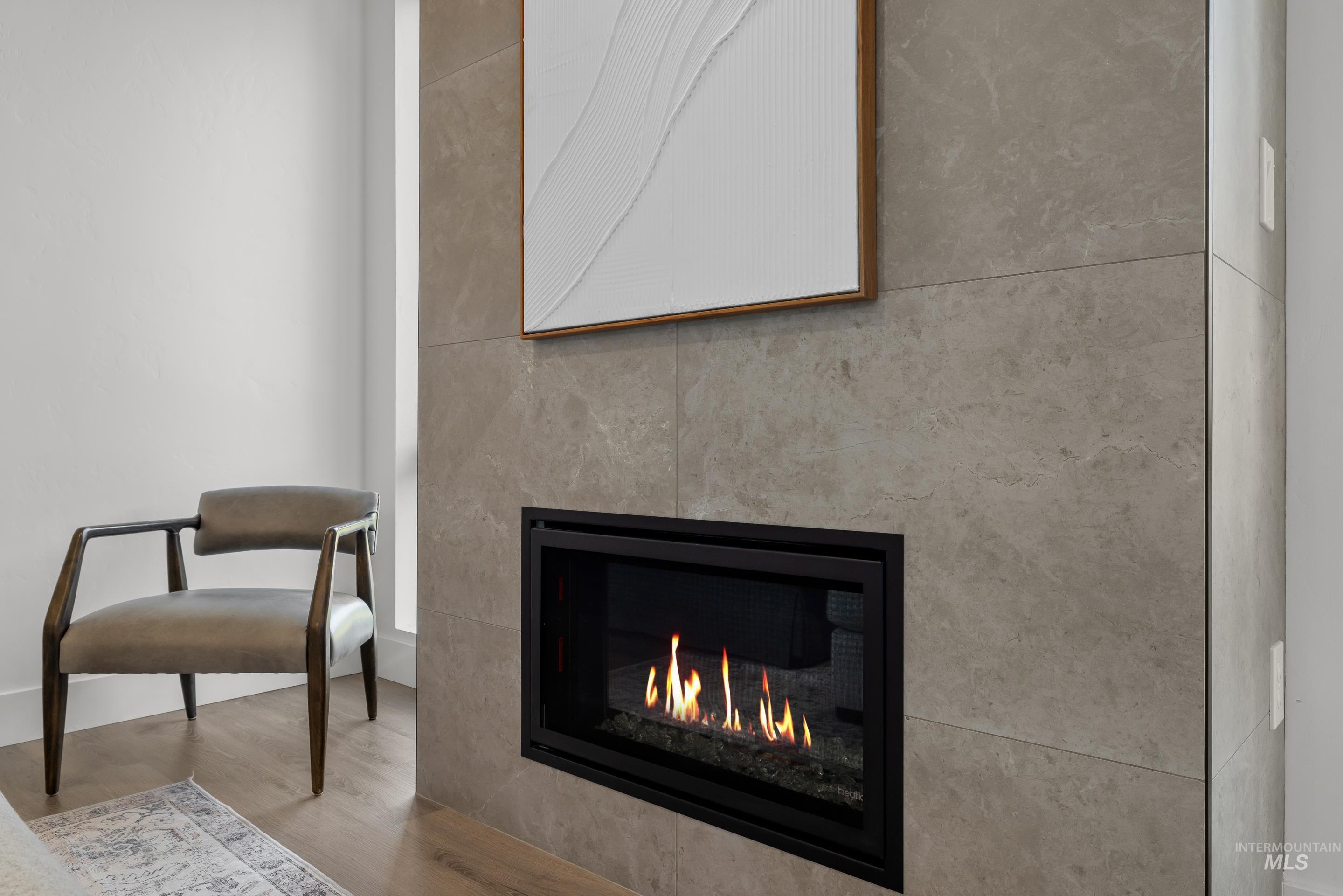 Detailed view of wood finished floors and a glass covered fireplace