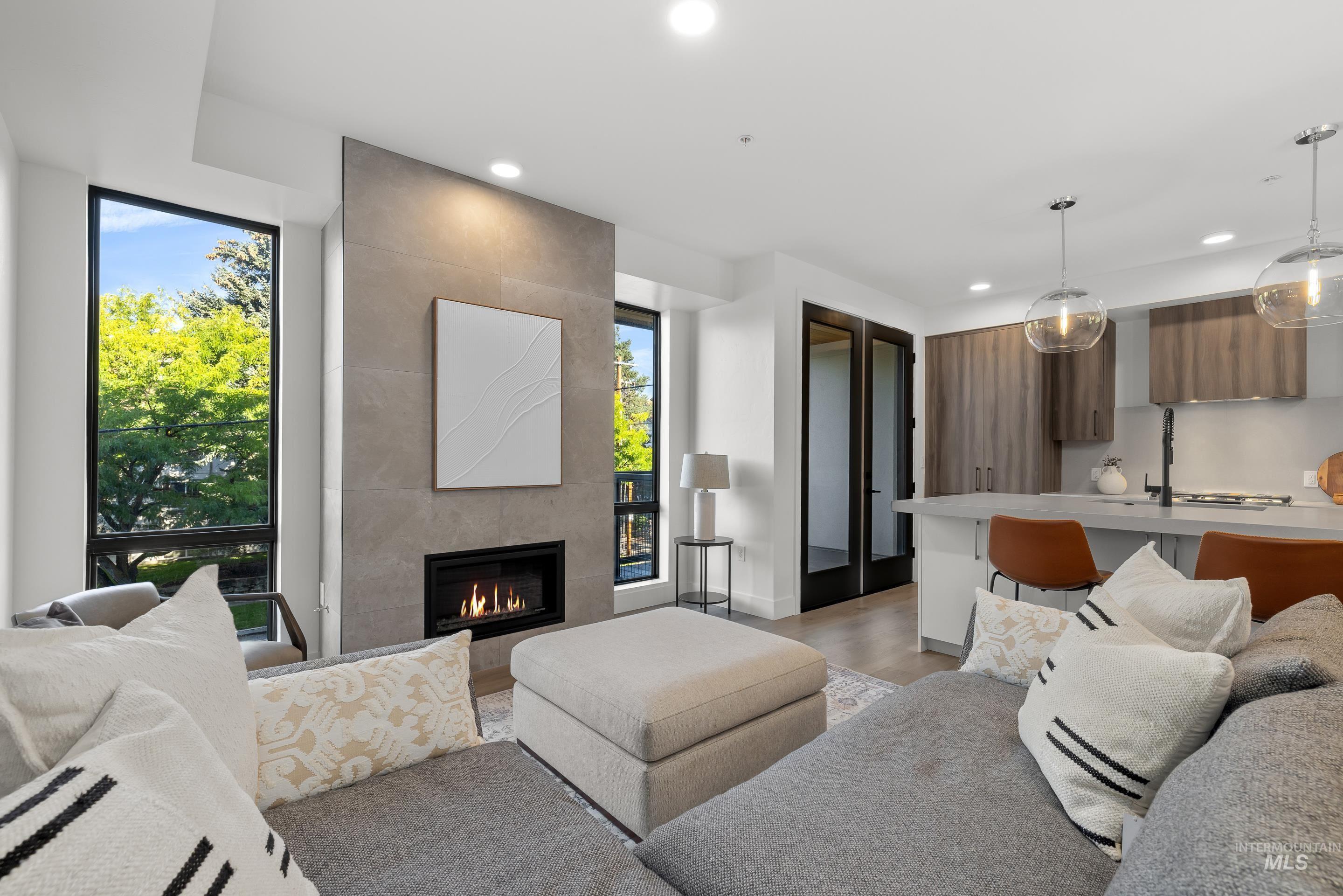 Living area with light wood-style floors, recessed lighting, and a tile fireplace