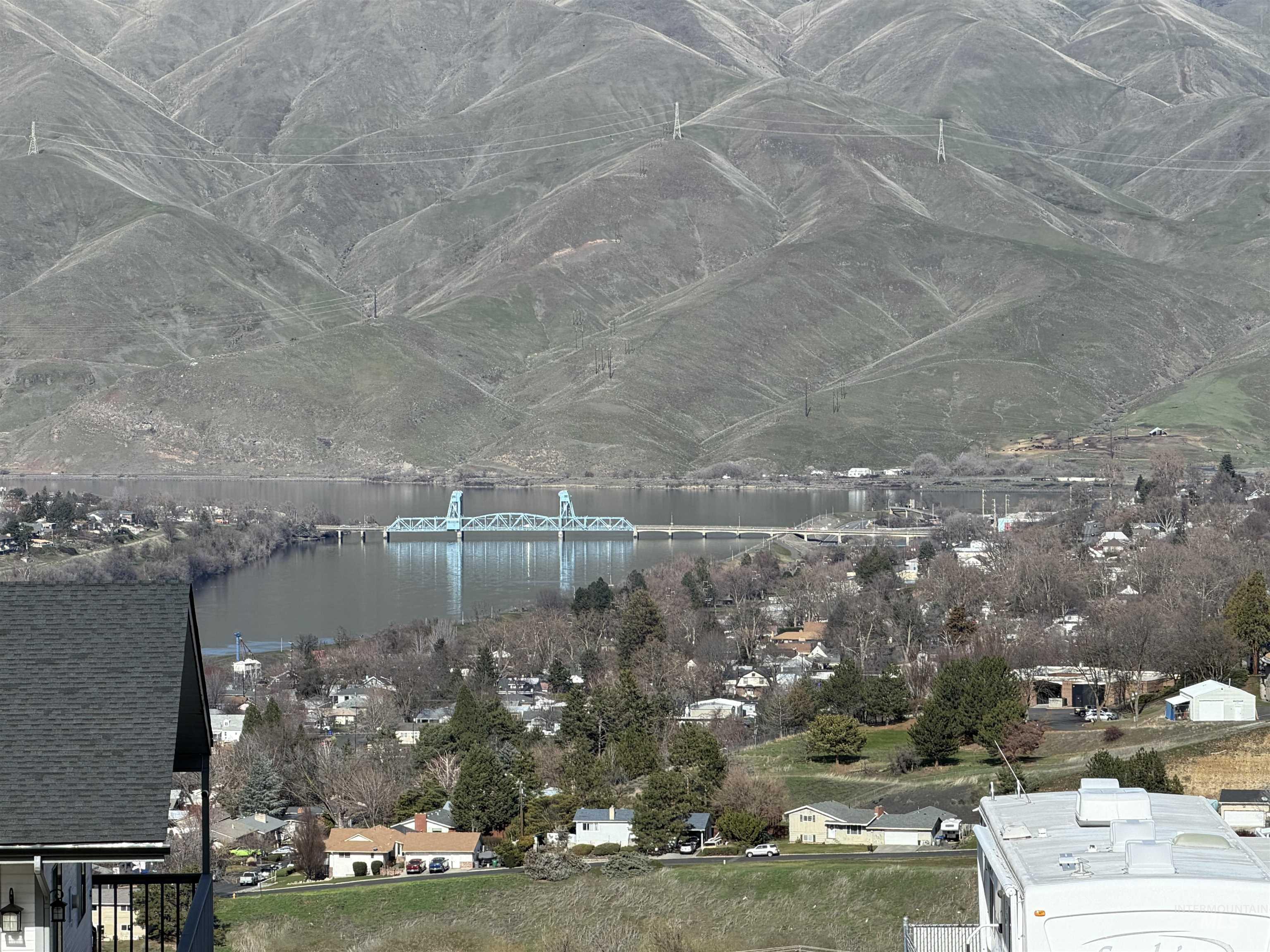 View of mountain backdrop with a nearby body of water and nearby suburban area