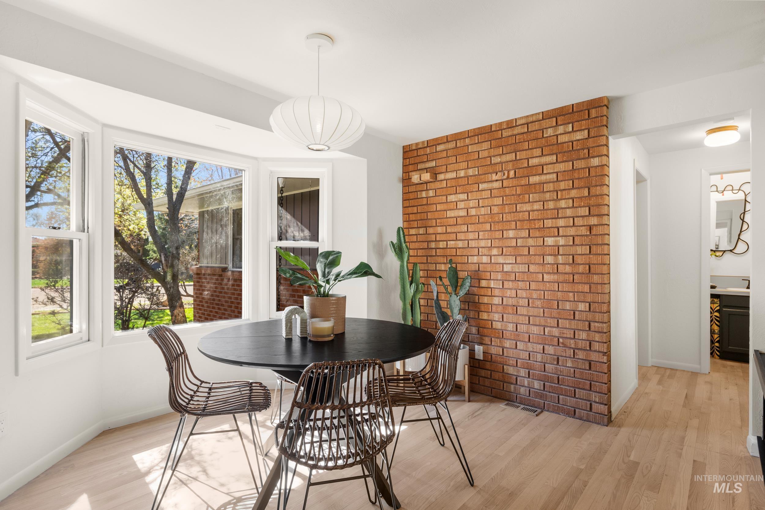 Dining space featuring light wood finished floors and brick wall
