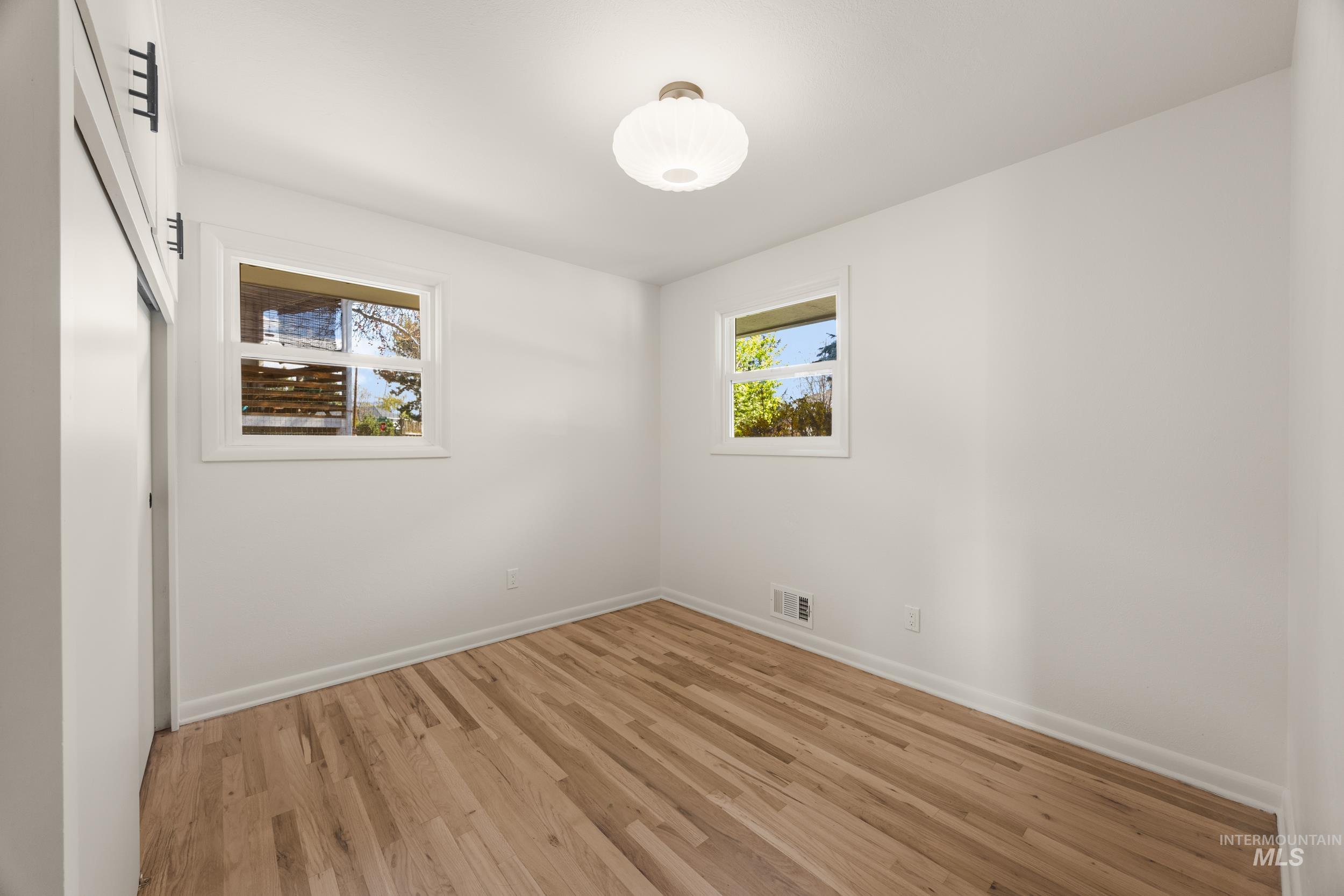 Spare room featuring light wood finished floors and baseboards