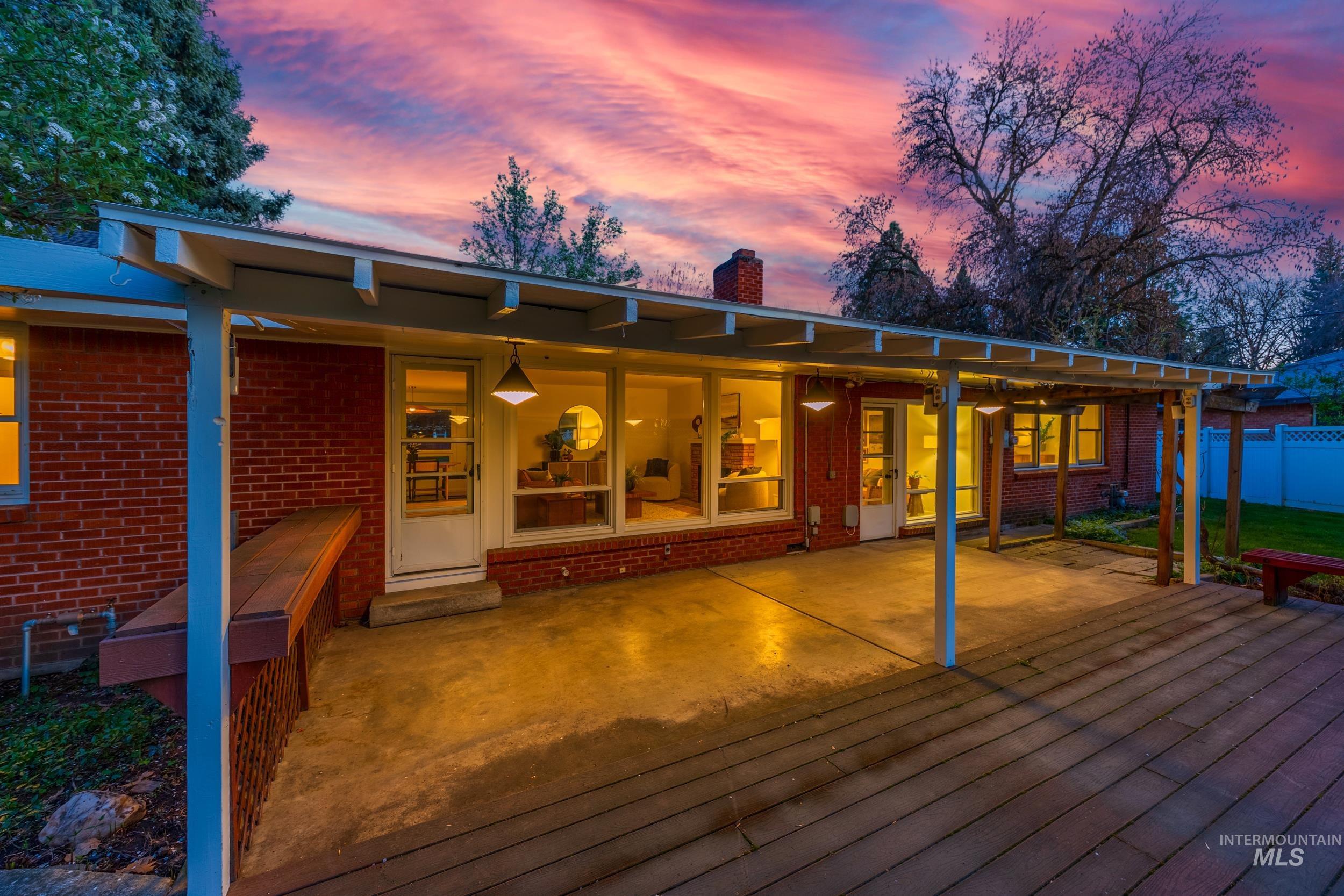 Back of property featuring a patio area, a chimney, and brick siding