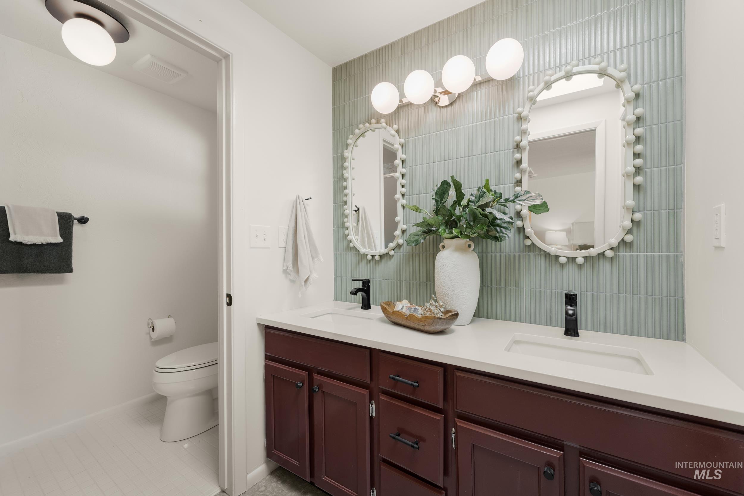 Full bath with double vanity and light tile patterned floors
