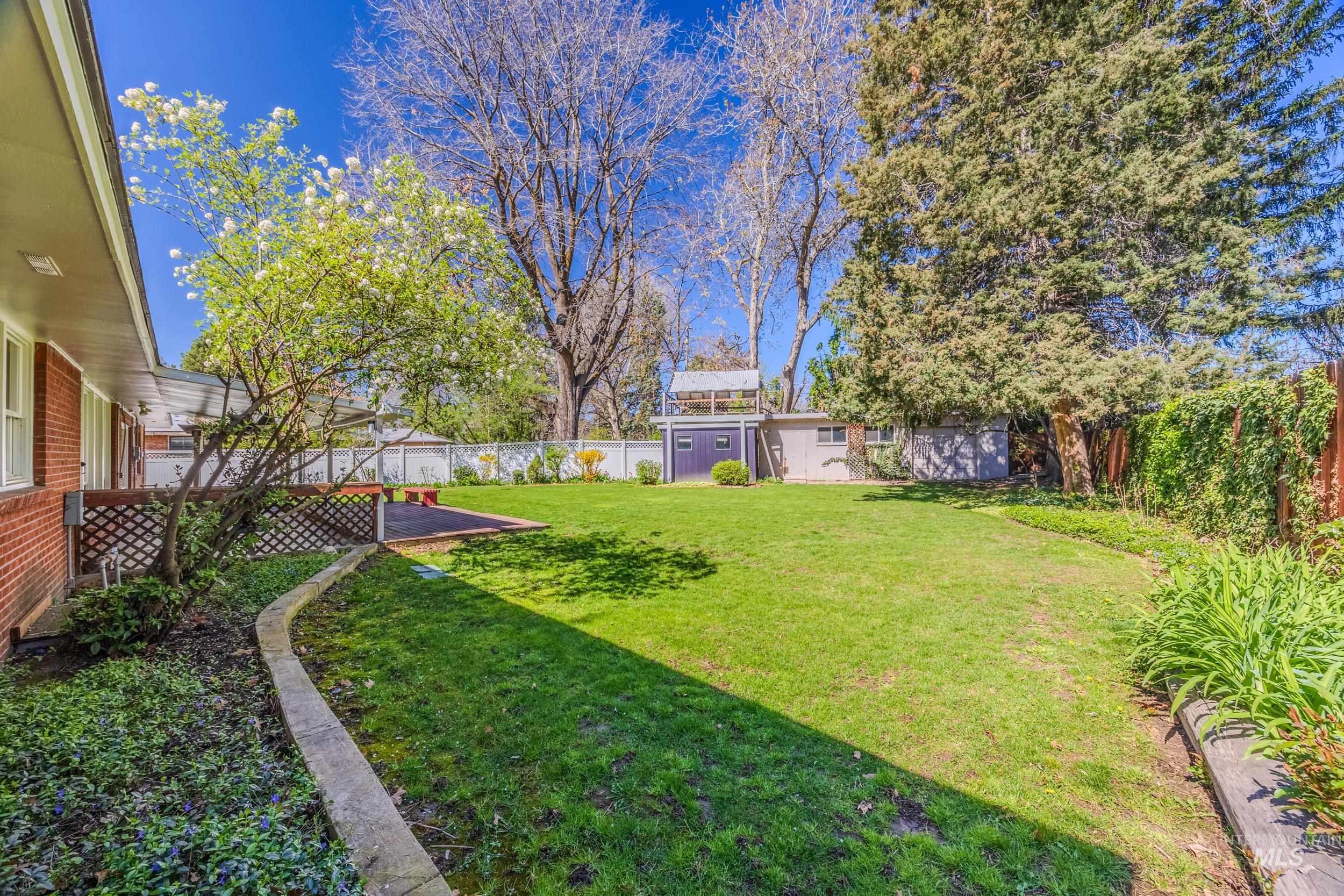 Fenced backyard with an outdoor structure