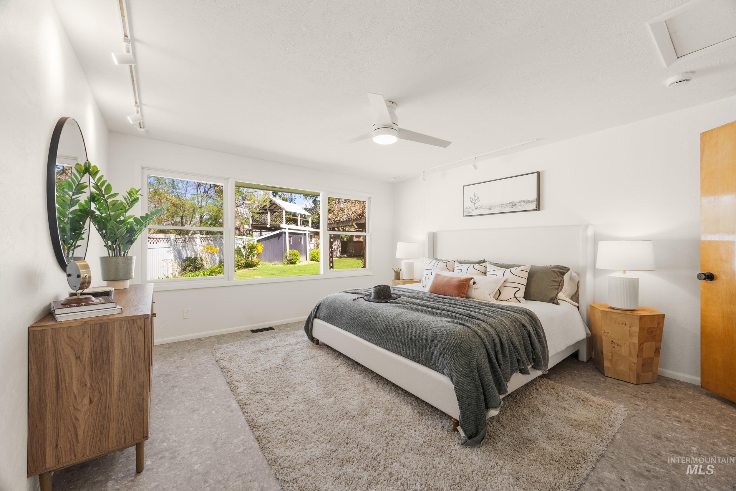Bedroom with track lighting and ceiling fan