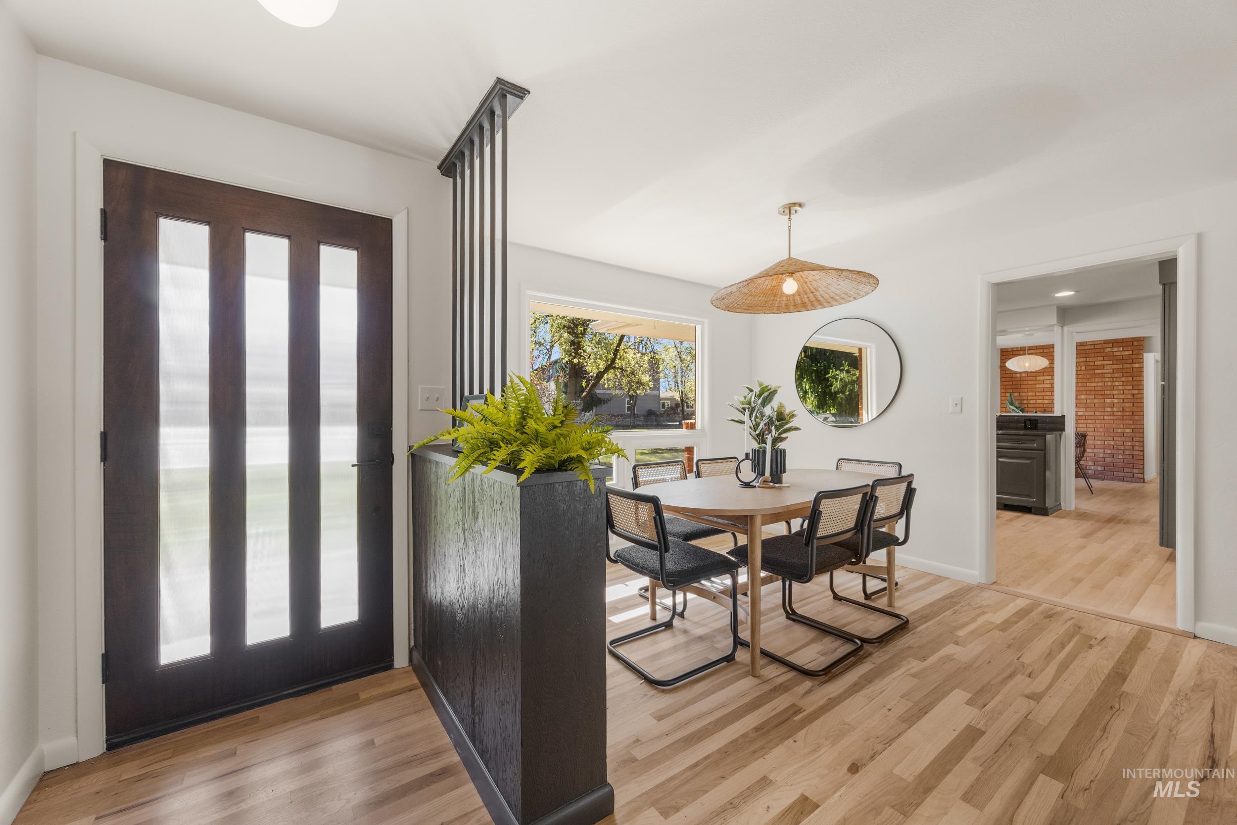 Entrance foyer featuring light wood-type flooring and brick wall