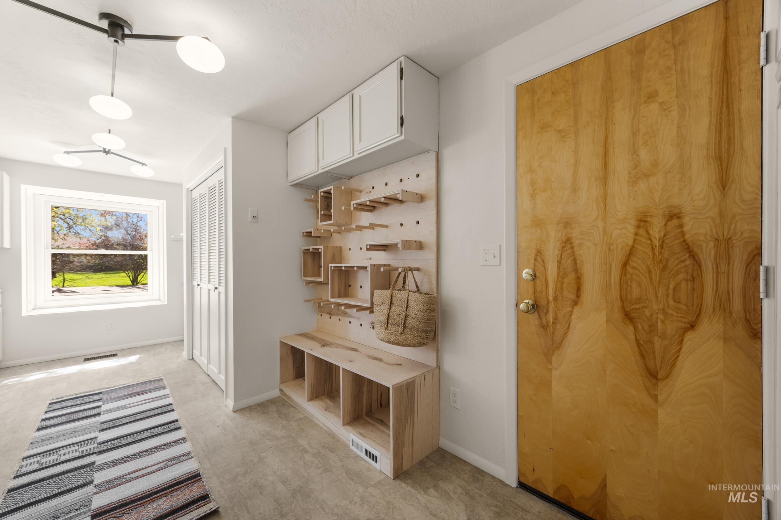 Mudroom featuring light colored carpet and baseboards