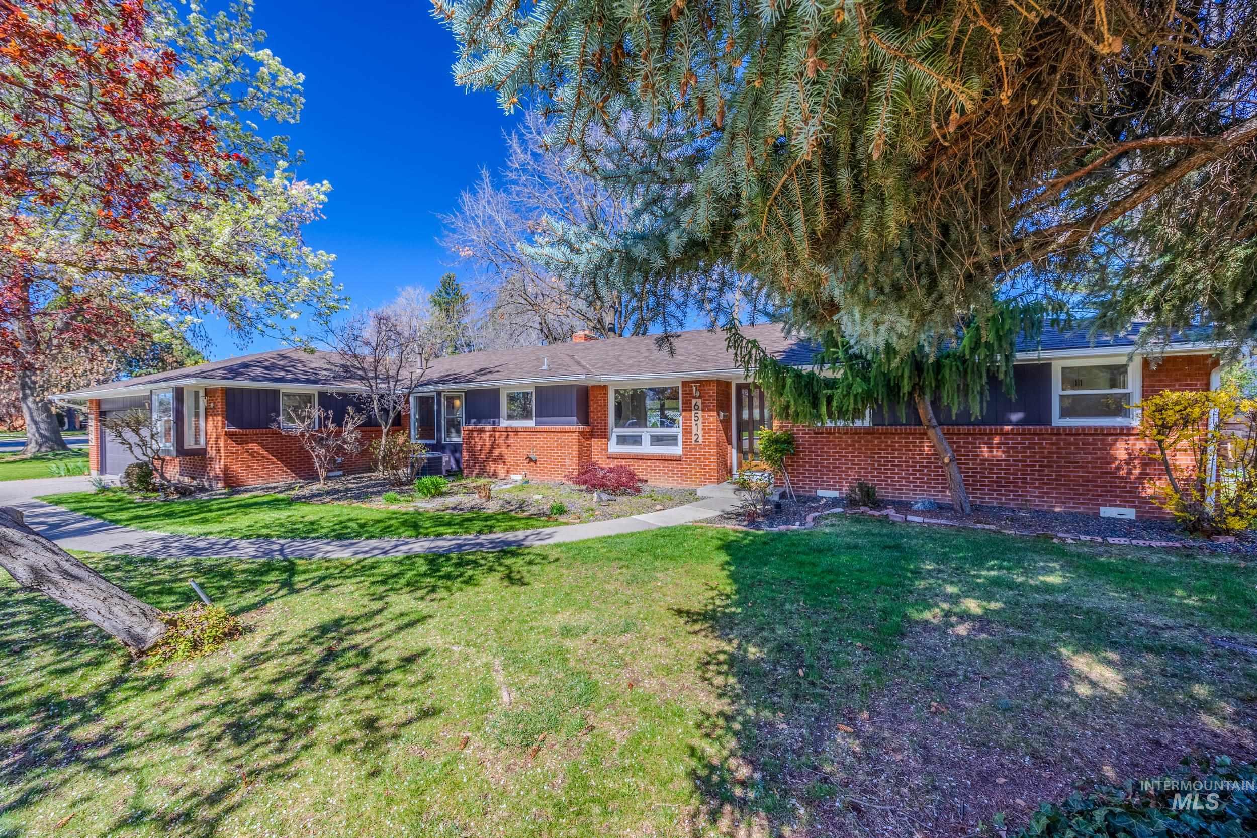 Ranch-style home with brick siding, a front lawn, and a garage