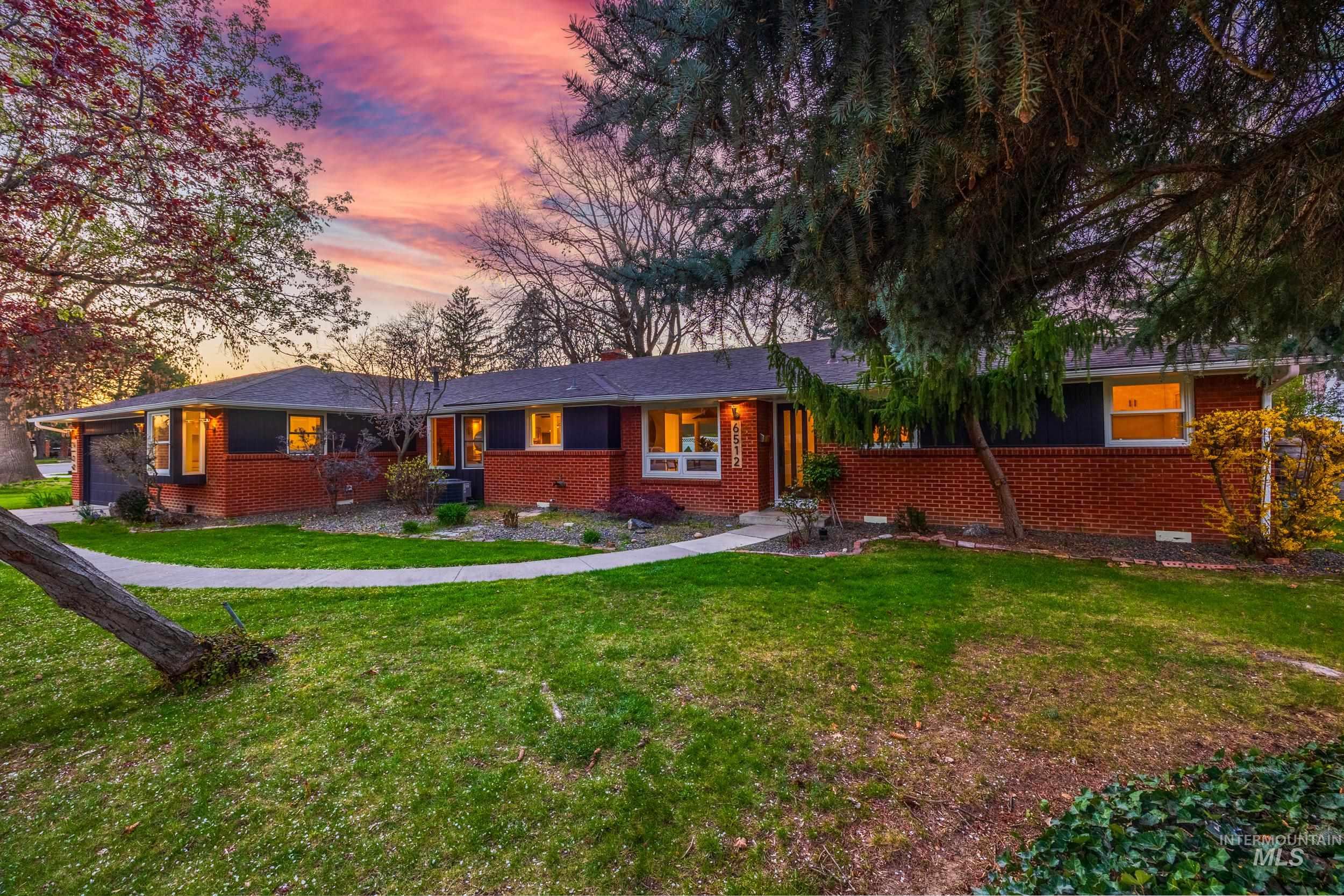 Ranch-style home with a front lawn, brick siding, a garage, and crawl space