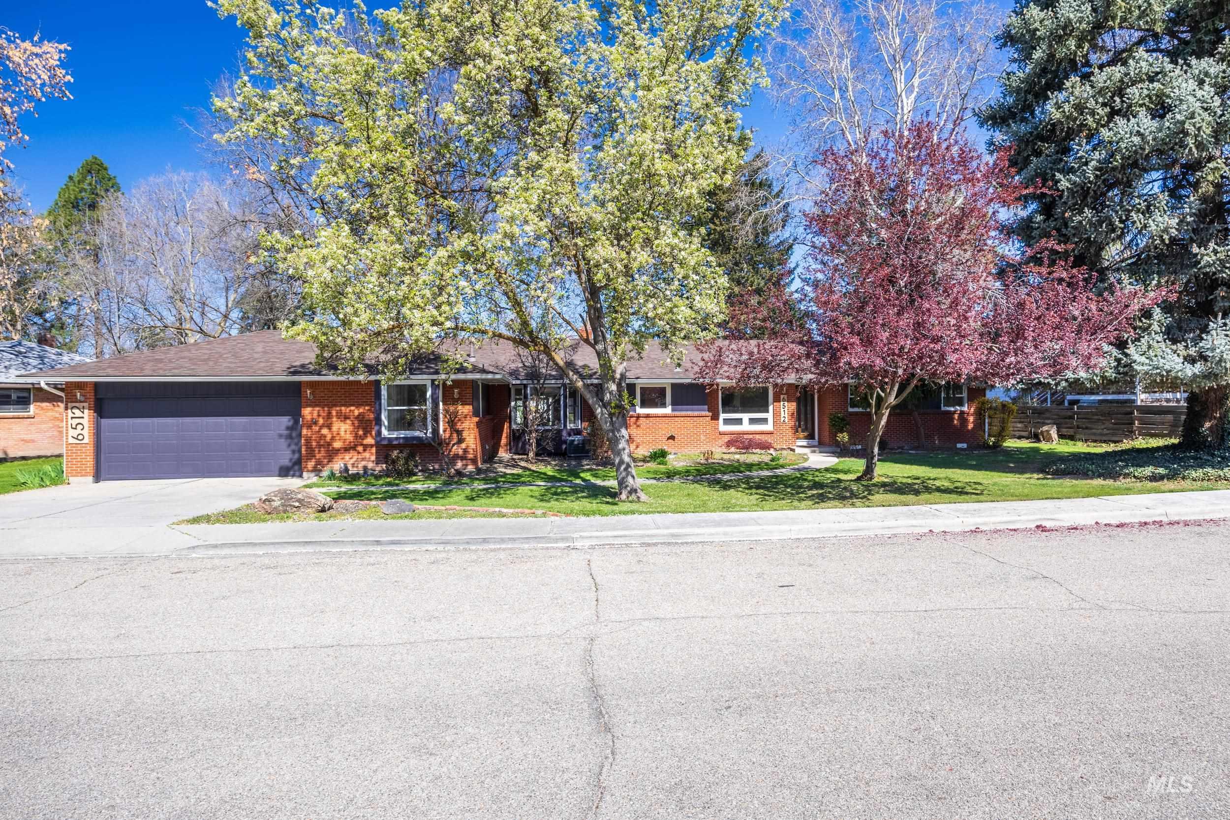 Single story home featuring an attached garage, brick siding, and concrete driveway