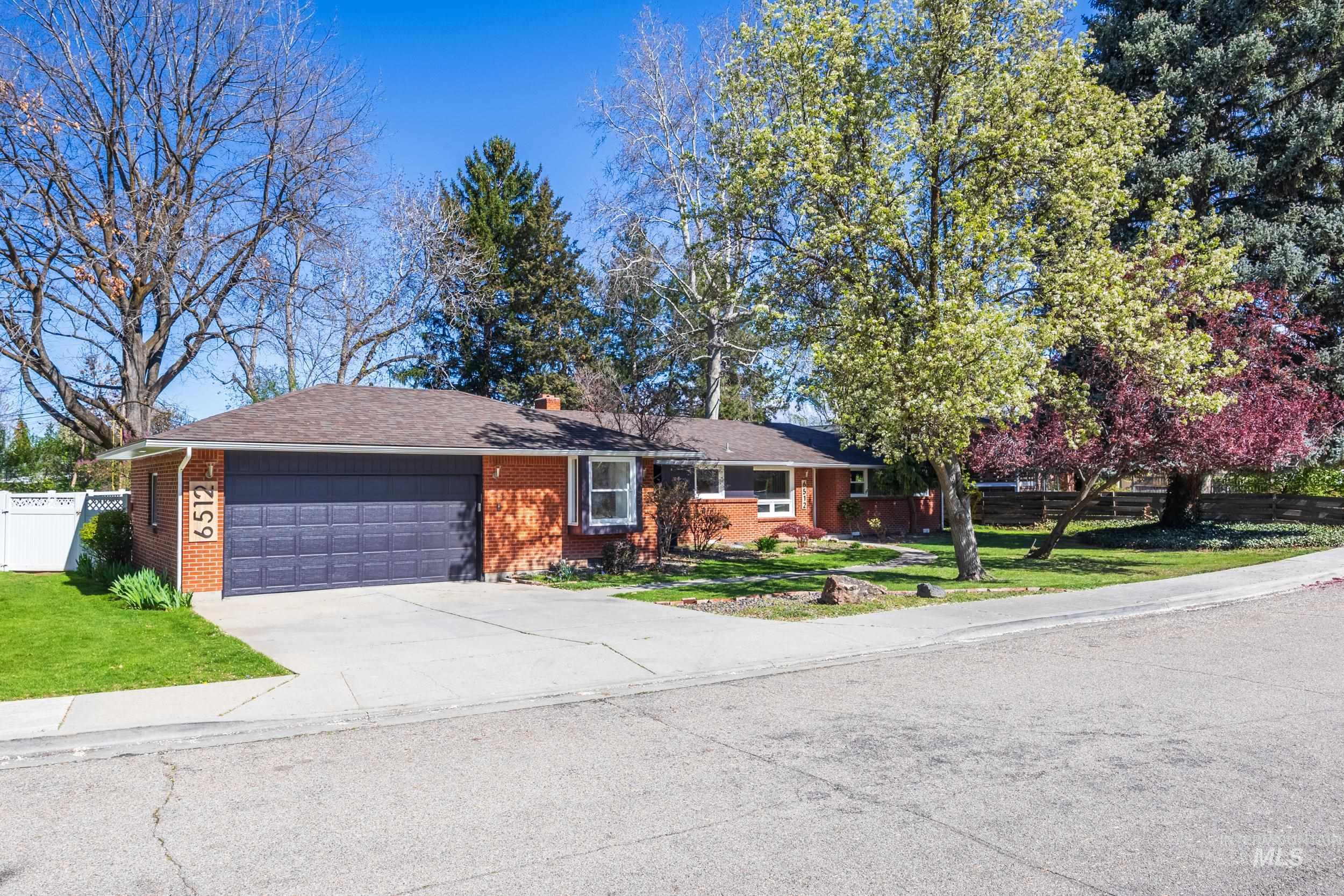 Ranch-style home with a garage, brick siding, and driveway