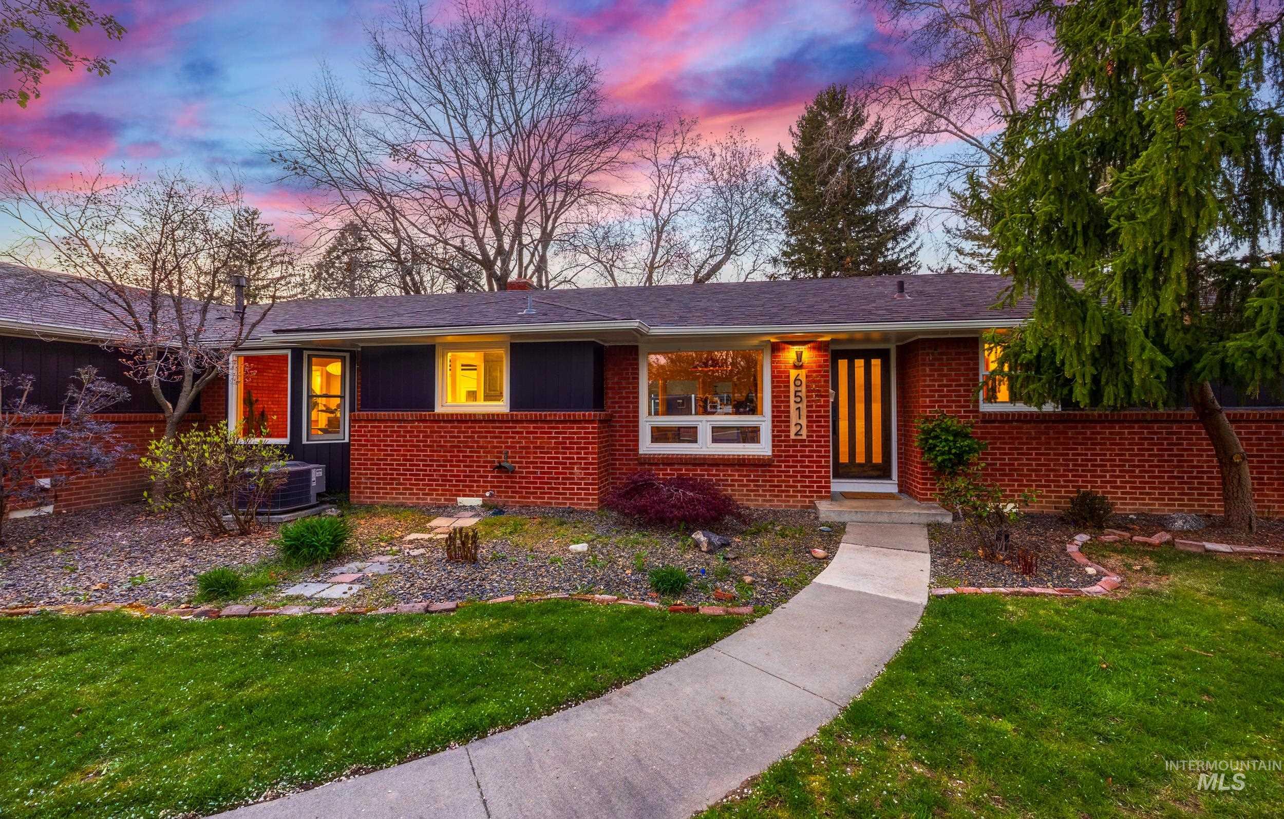 Ranch-style house with a lawn, brick siding, and a chimney