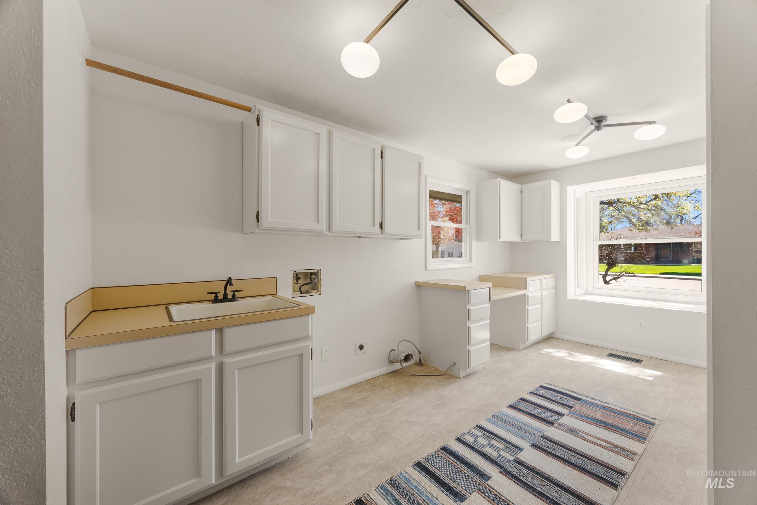 Laundry room featuring hookup for a washing machine, cabinet space, electric dryer hookup, and light colored carpet