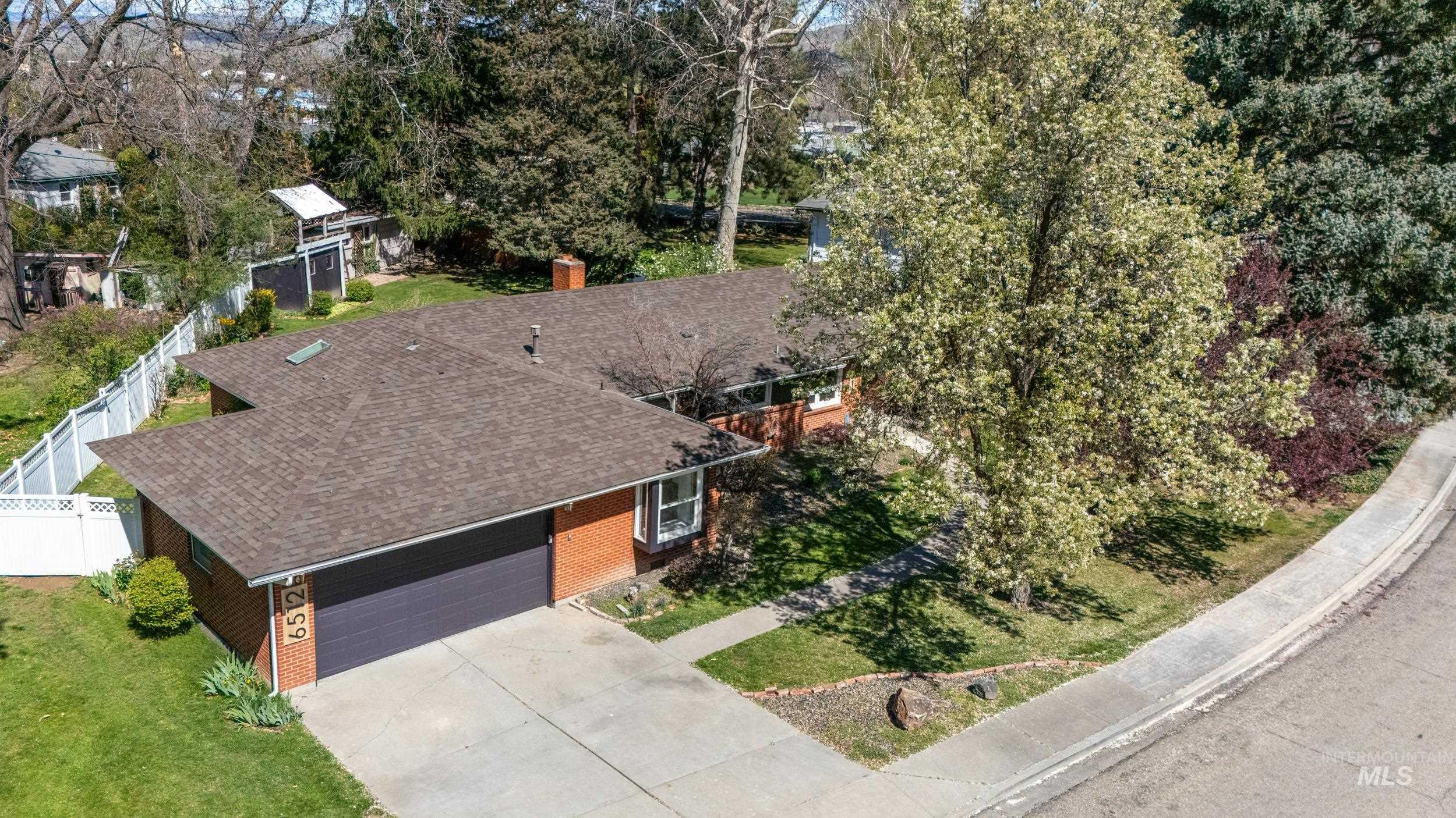 Aerial view of property and surrounding area featuring a tree filled landscape