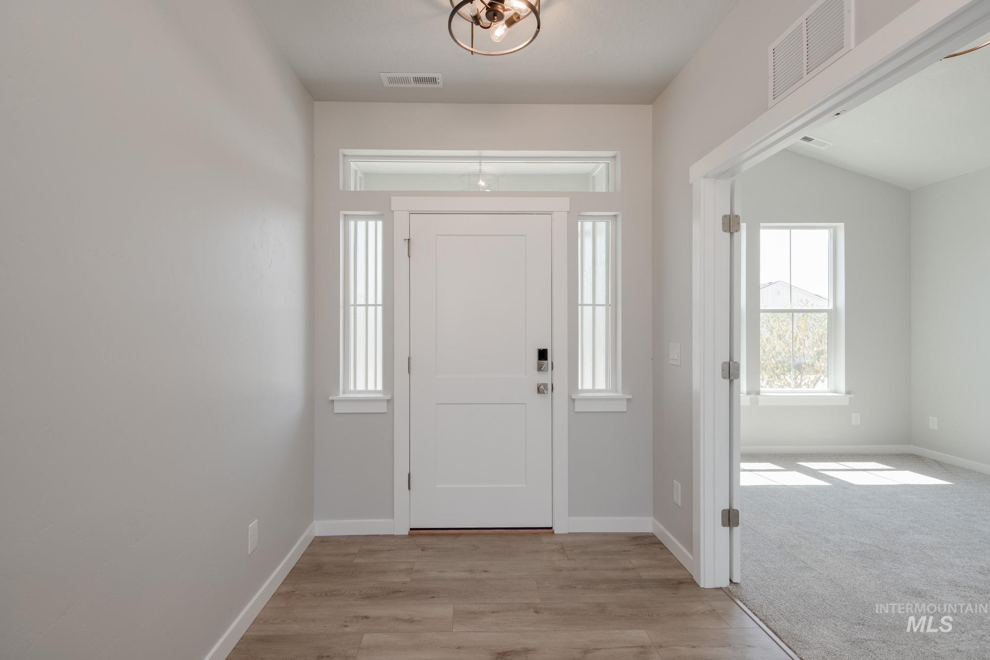 Entryway featuring light wood-type flooring and light carpet
