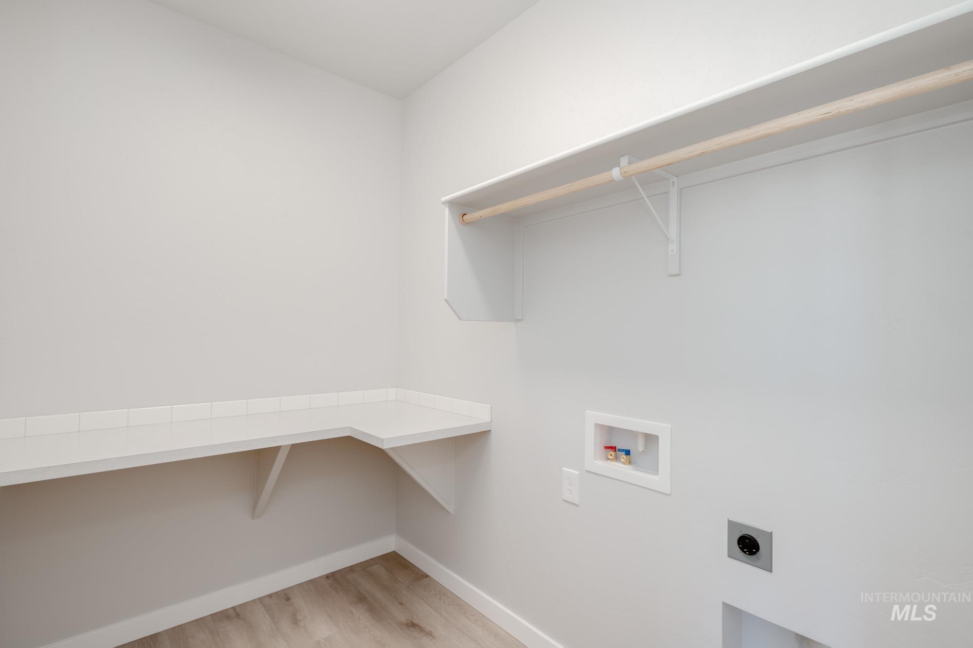 Laundry room featuring hookup for an electric dryer, hookup for a washing machine, and light wood-type flooring