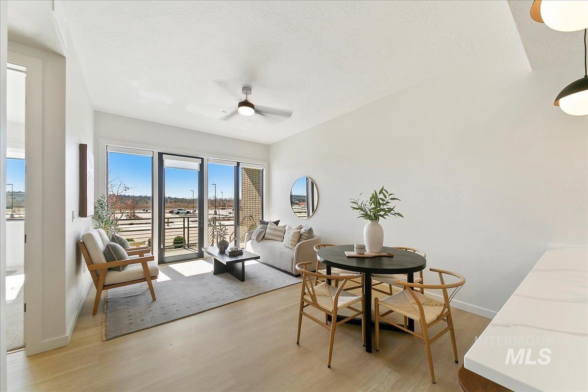 Dining room with light wood-style floors, a textured ceiling, and ceiling fan