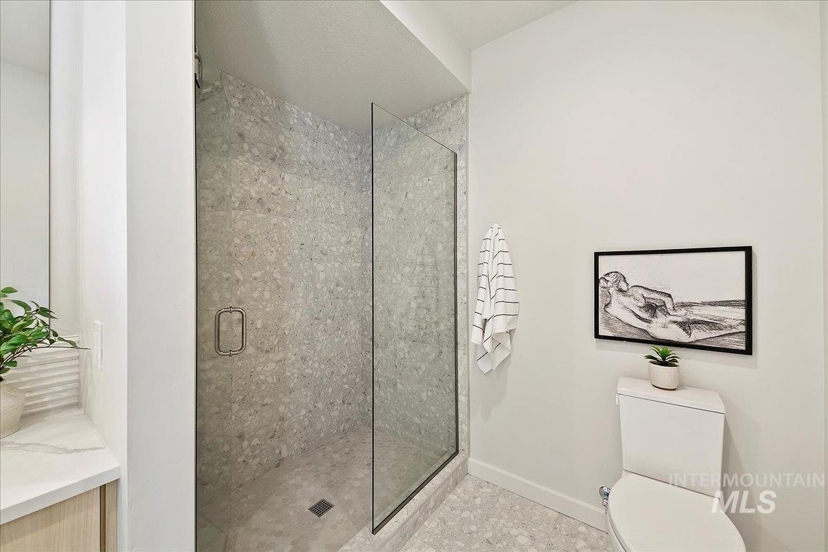 Bathroom with a shower stall and toilet