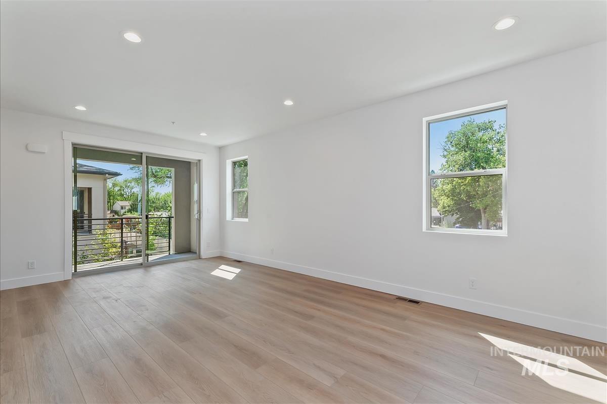 Spare room featuring plenty of natural light, recessed lighting, and light wood-type flooring
