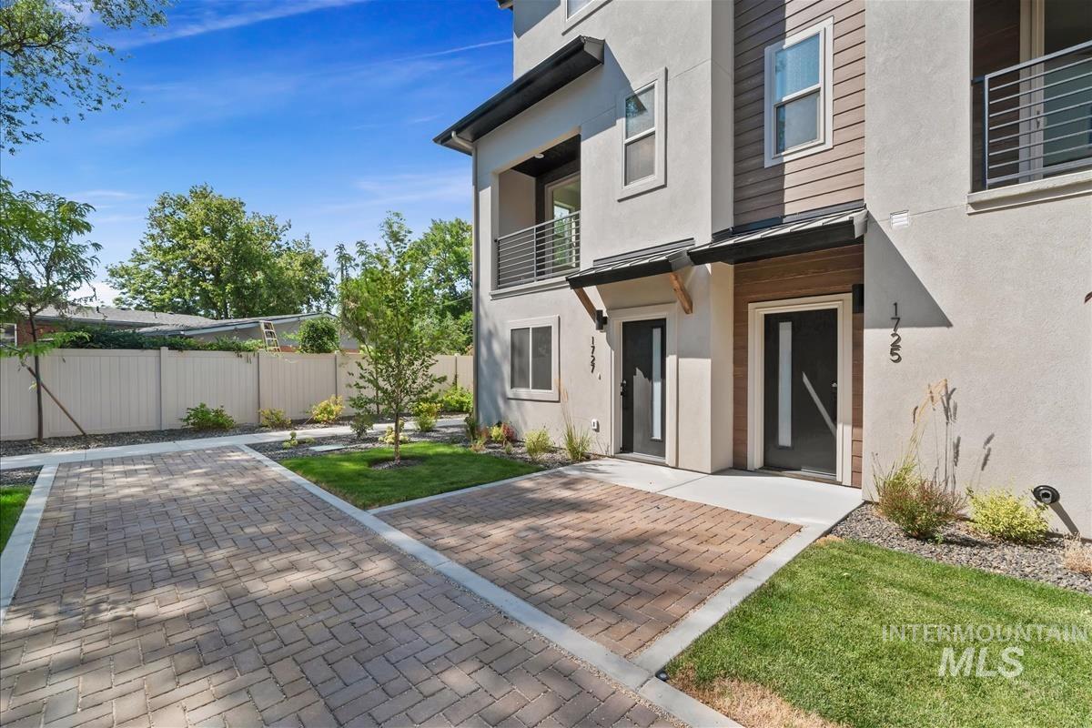 Back of property featuring a balcony and stucco siding