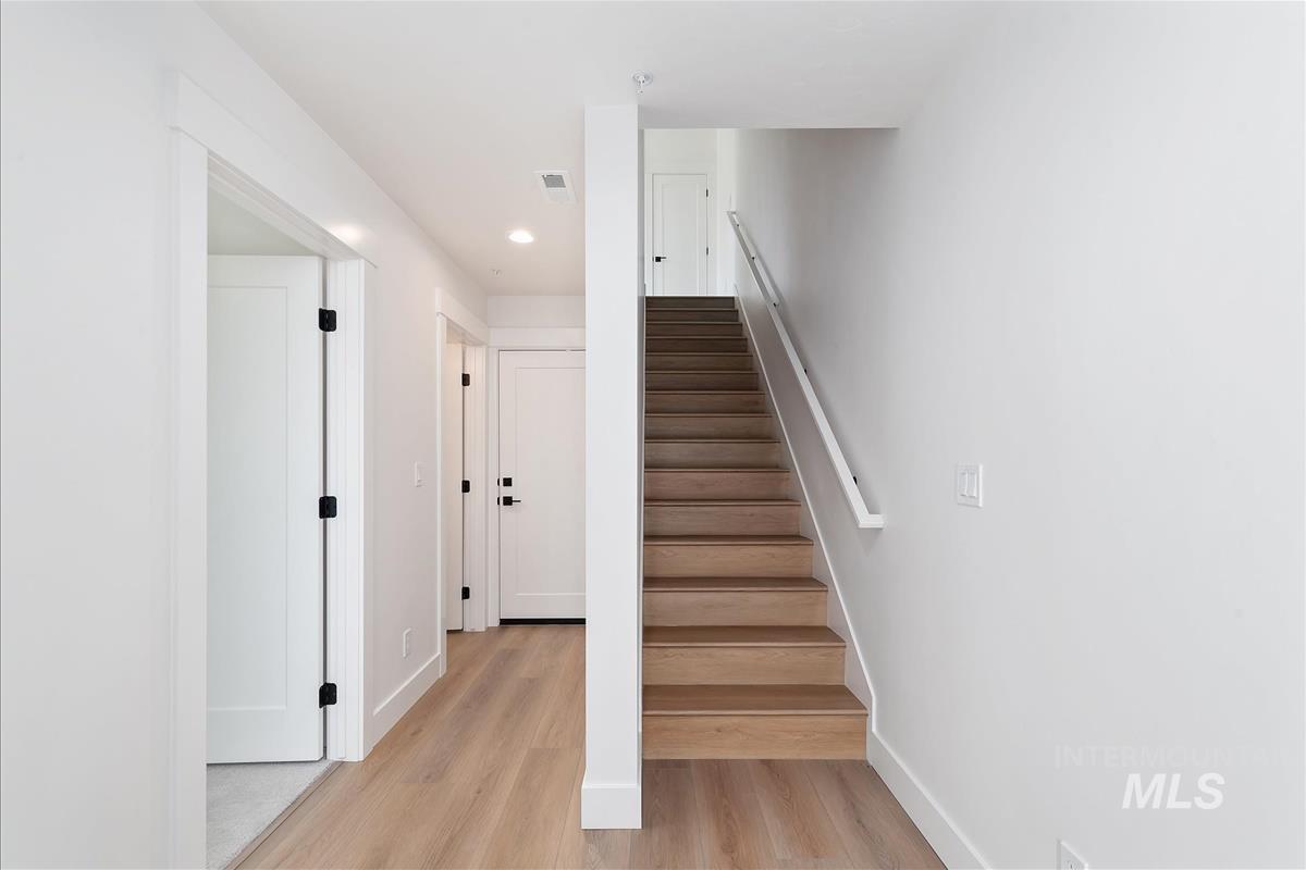 Staircase featuring wood finished floors and recessed lighting