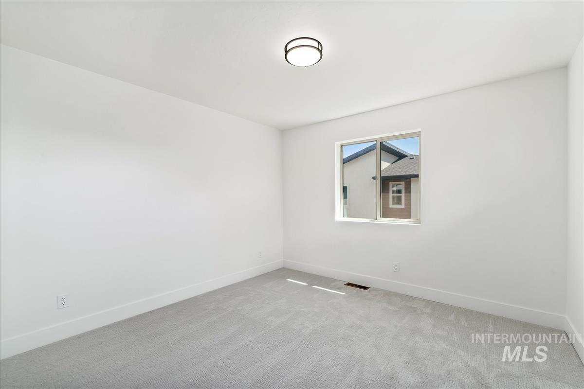 Carpeted empty room with baseboards