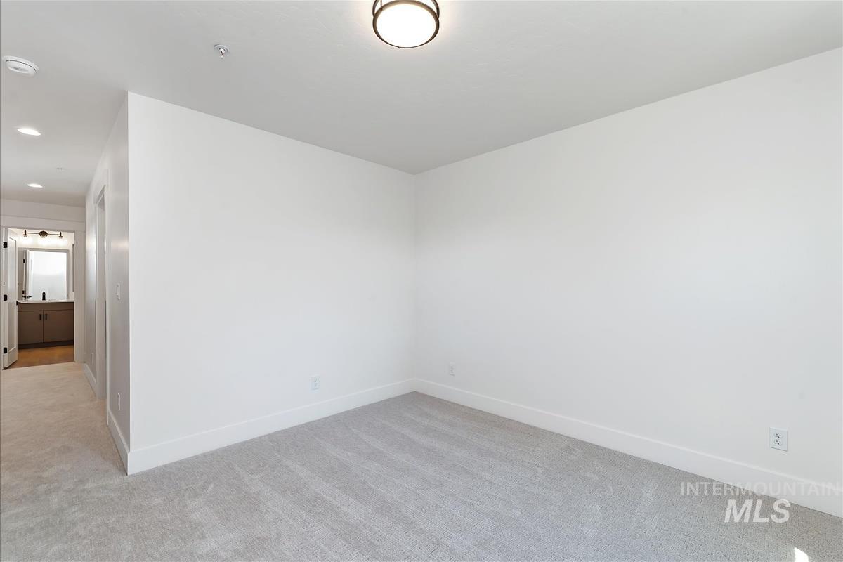 Spare room featuring light colored carpet and recessed lighting