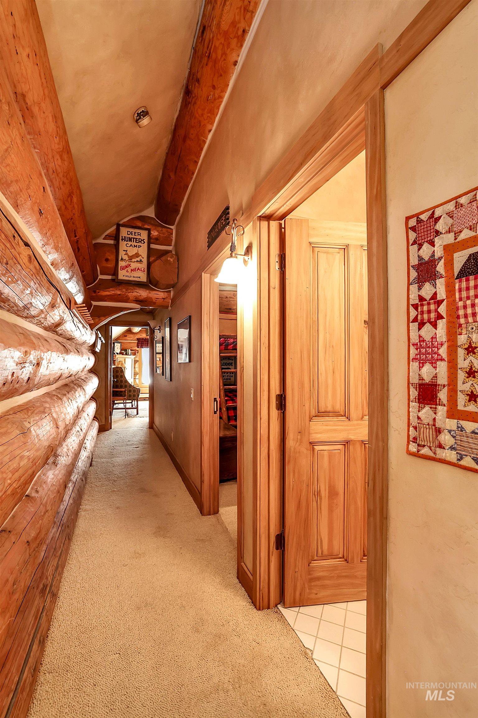Hallway featuring carpet floors and vaulted ceiling