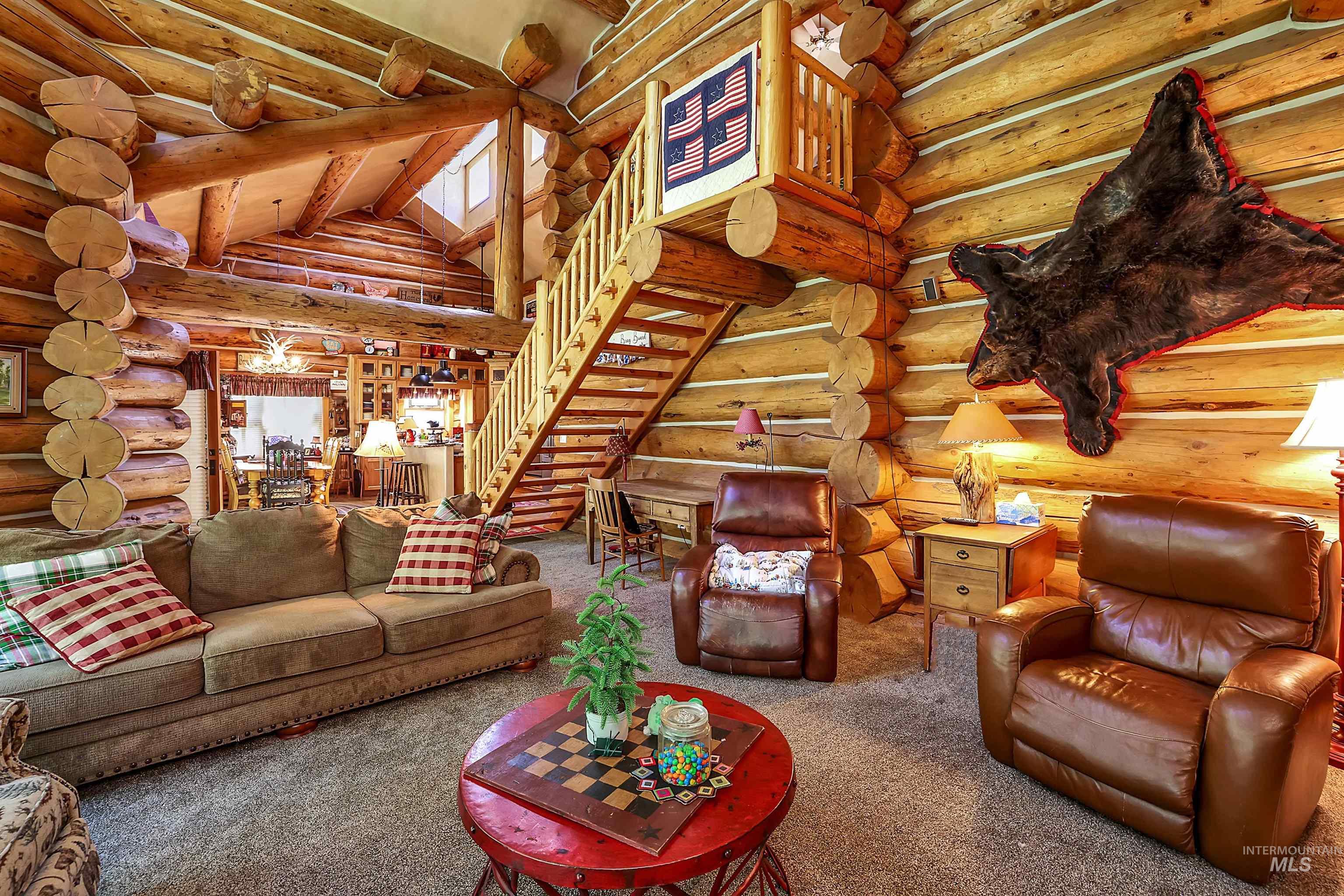 Carpeted living room featuring stairs and rustic walls