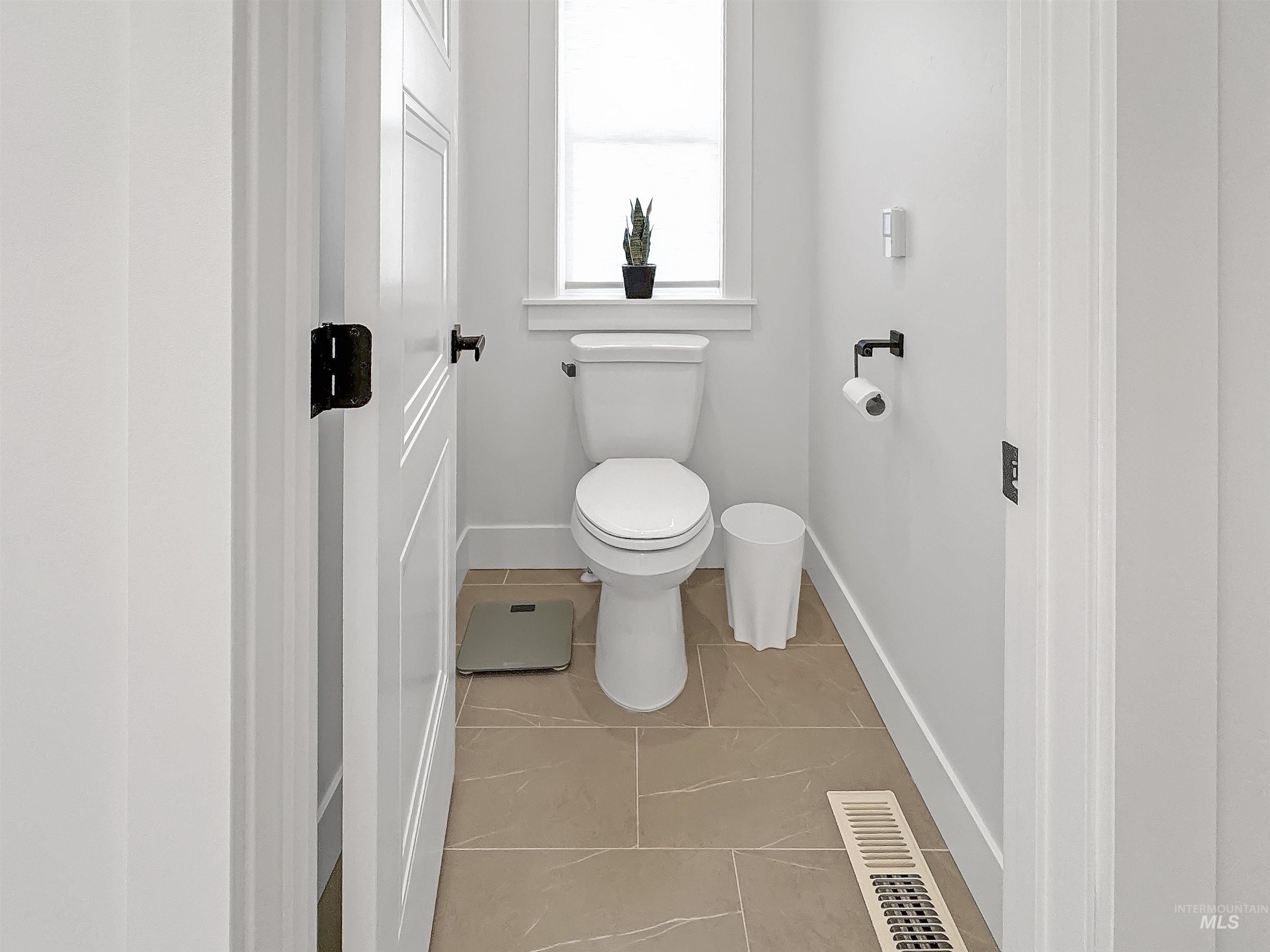Bathroom with light tile patterned floors and toilet