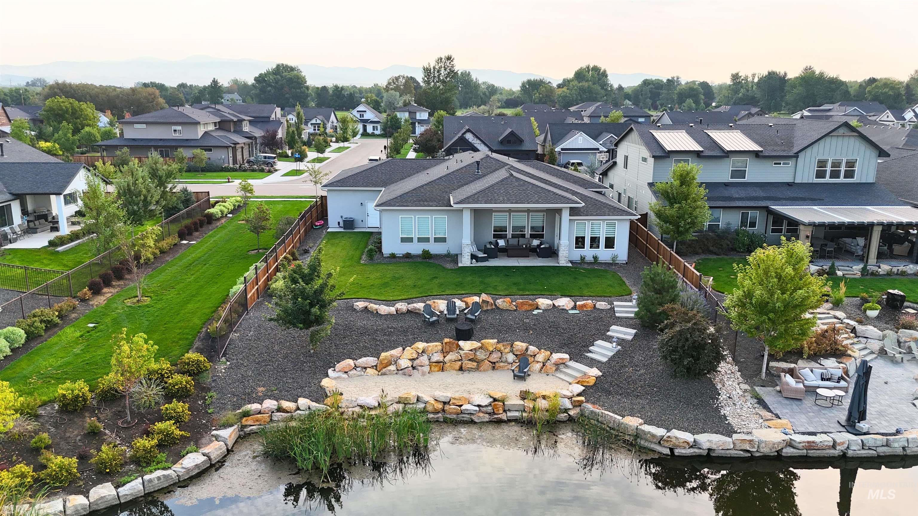 Aerial view of residential area featuring private sandy beach and pond access.