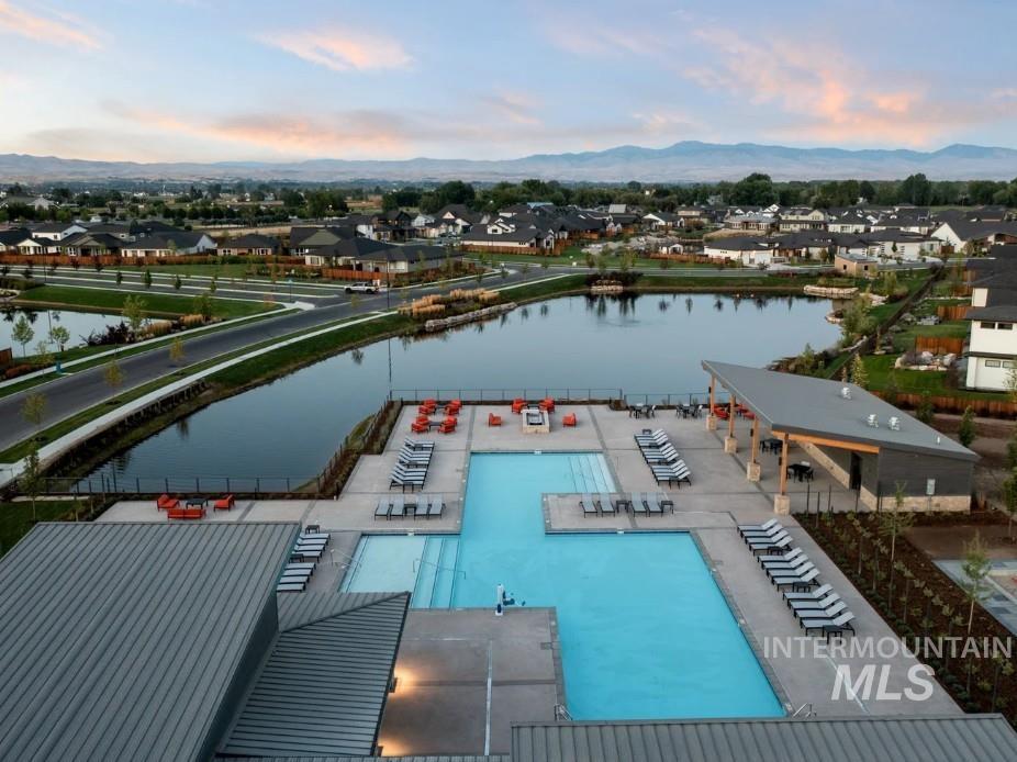 Aerial view of residential area featuring a water and mountain view and a pool area