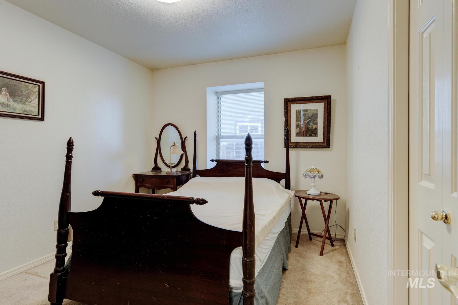 Bedroom featuring light carpet and baseboards