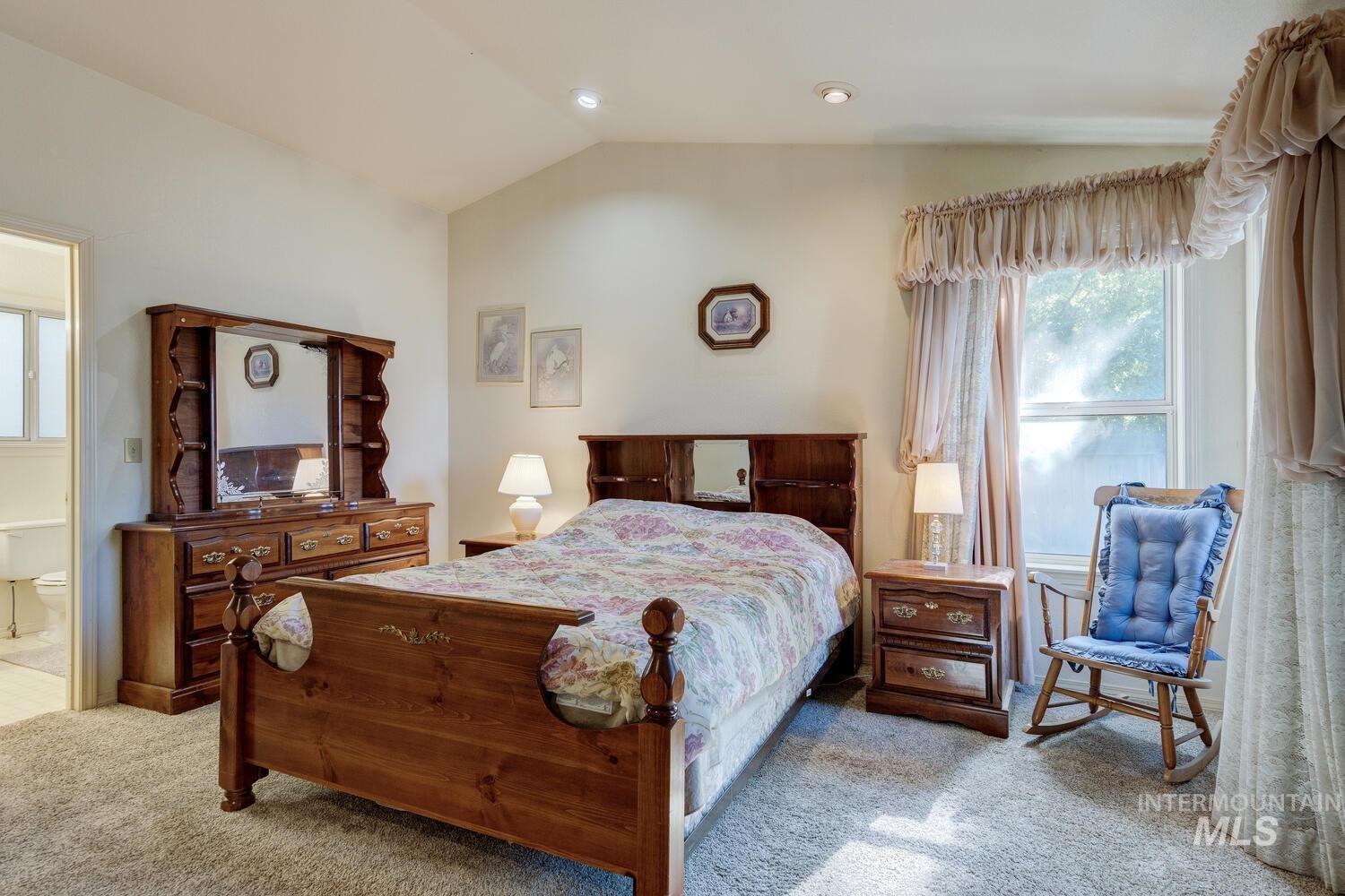 Bedroom with vaulted ceiling, carpet flooring, ensuite bathroom, and recessed lighting