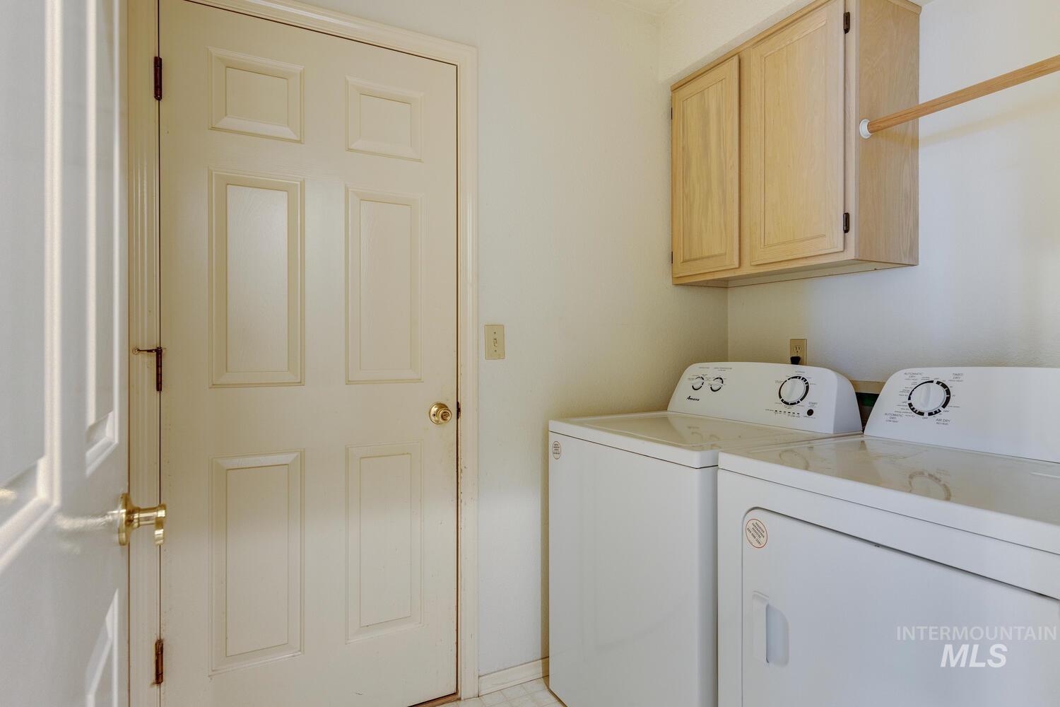 Washroom featuring cabinet space and washer and clothes dryer