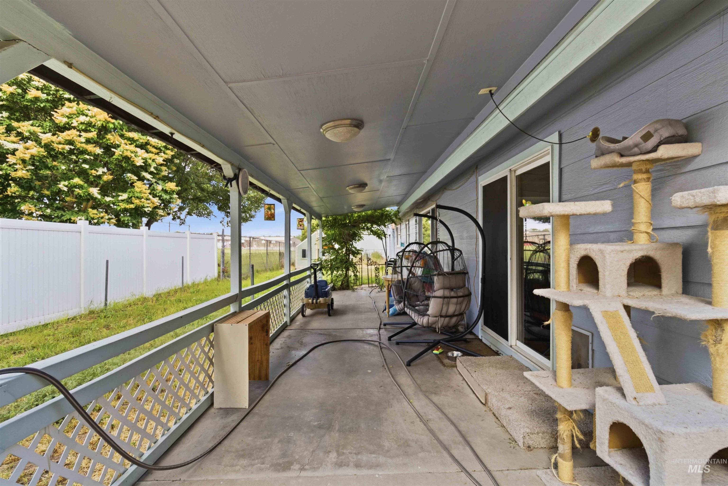 Covered patio with concrete flooring, extending the length of the property