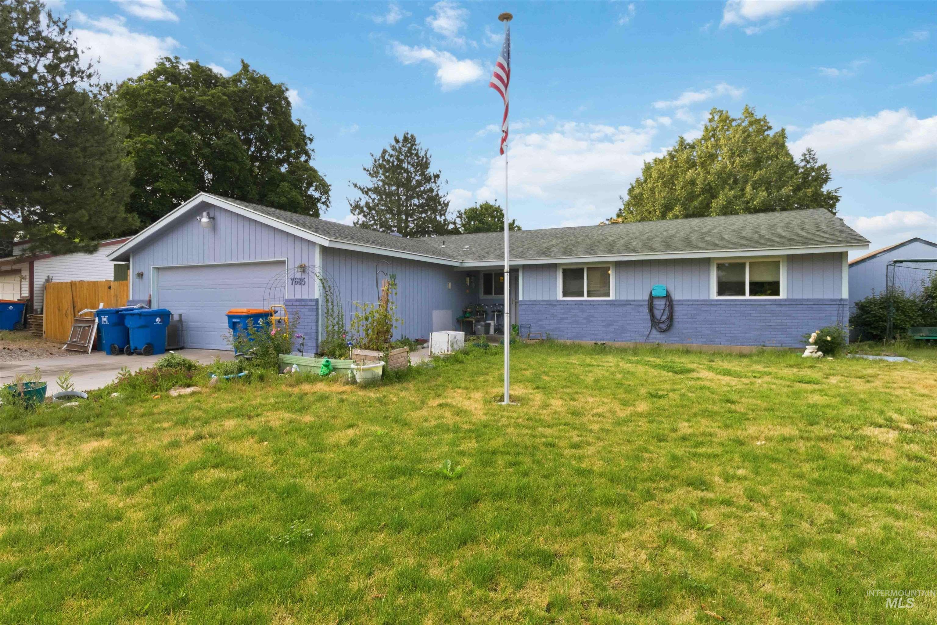 Ranch-style residence featuring light blue siding with a dark blue brick lower facade