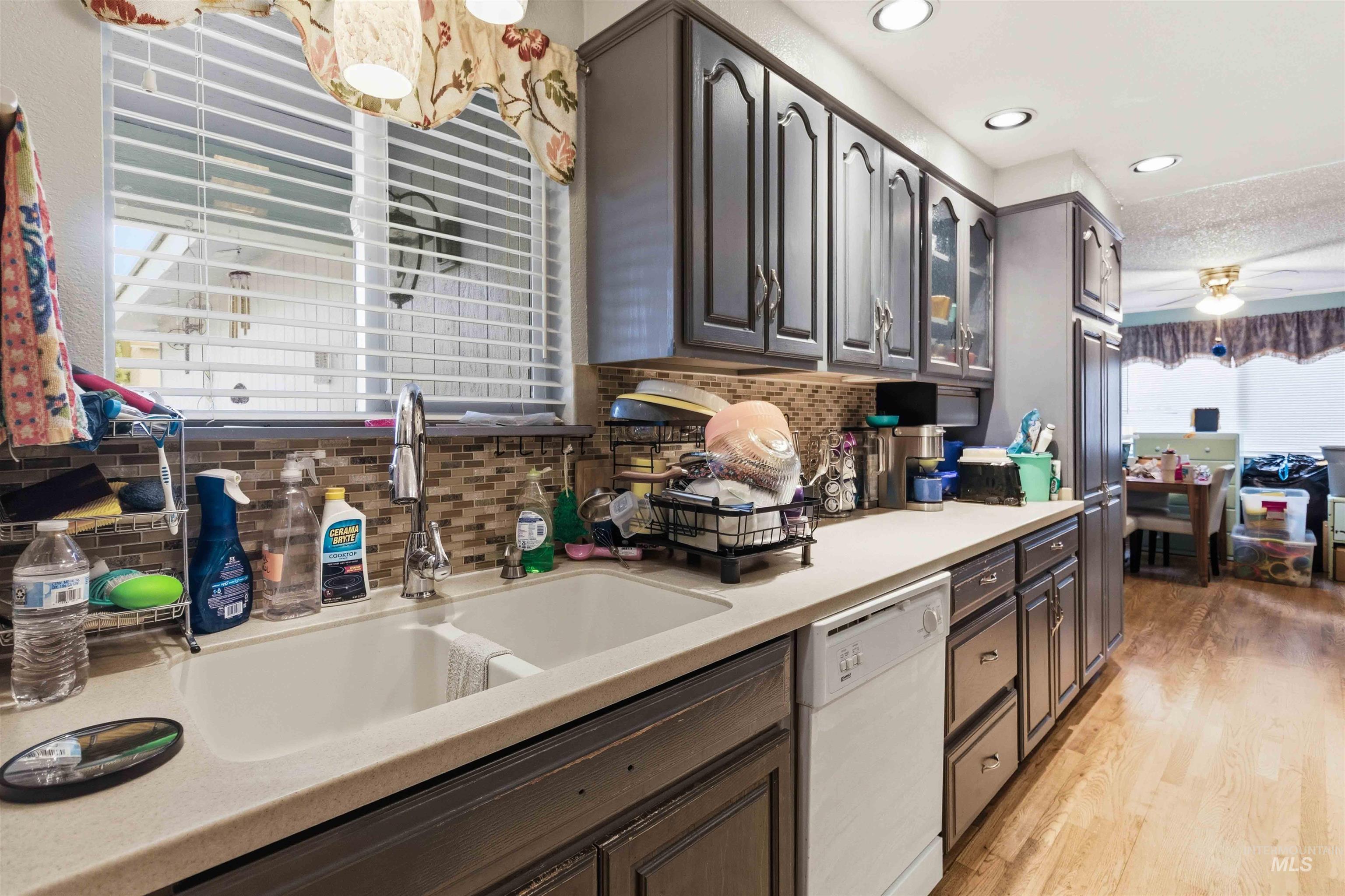 Kitchen featuring gray cabinetry, light countertops, and a mosaic tile backsplash