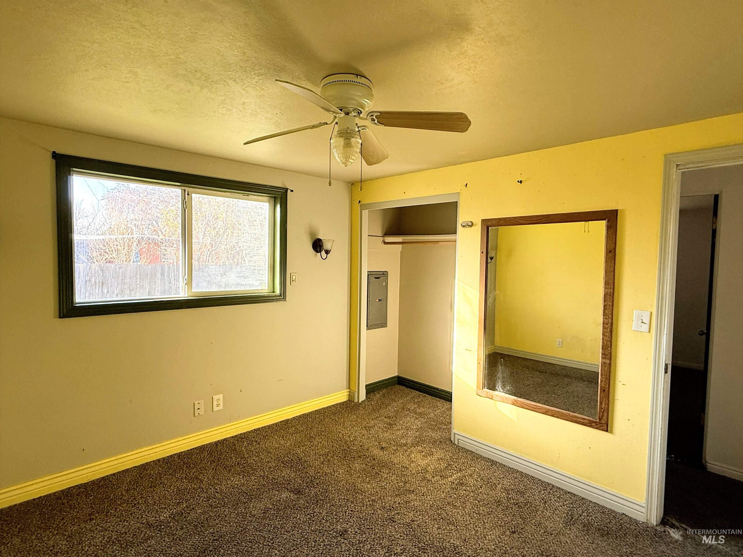 Unfurnished bedroom featuring a textured ceiling, carpet, ceiling fan, and a closet