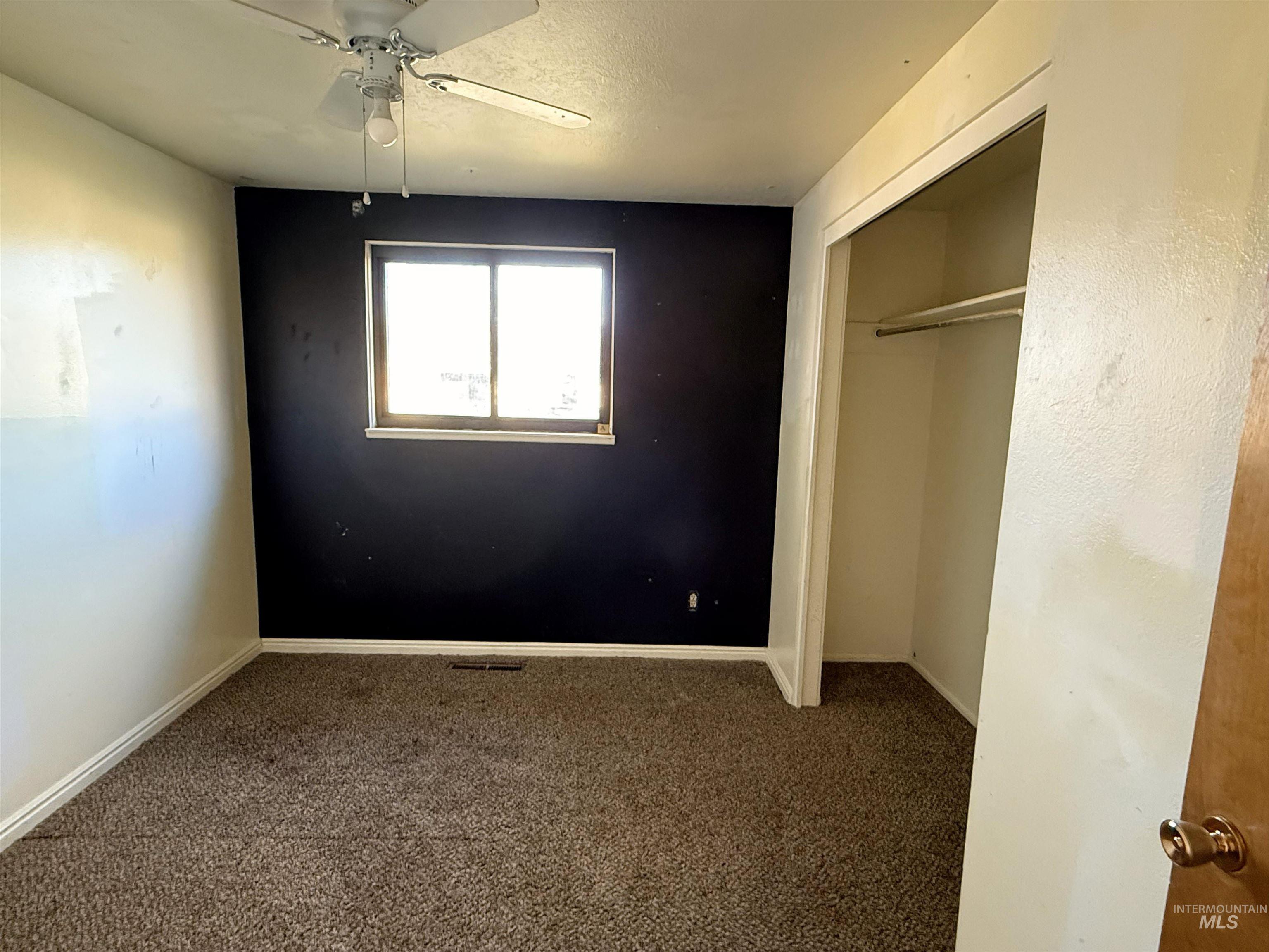 Unfurnished bedroom with carpet flooring, a closet, a ceiling fan, and a textured ceiling