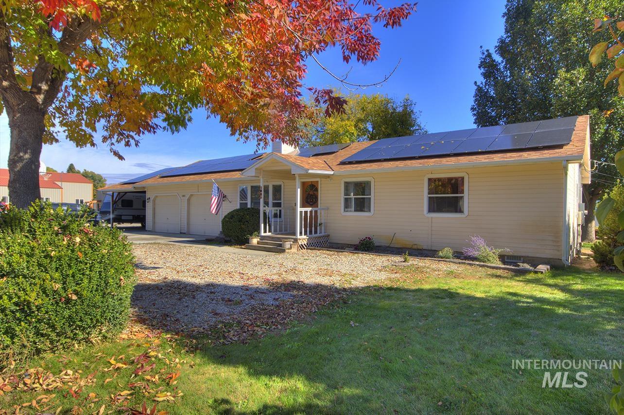 Ranch-style home featuring a garage, a front yard, and a chimney