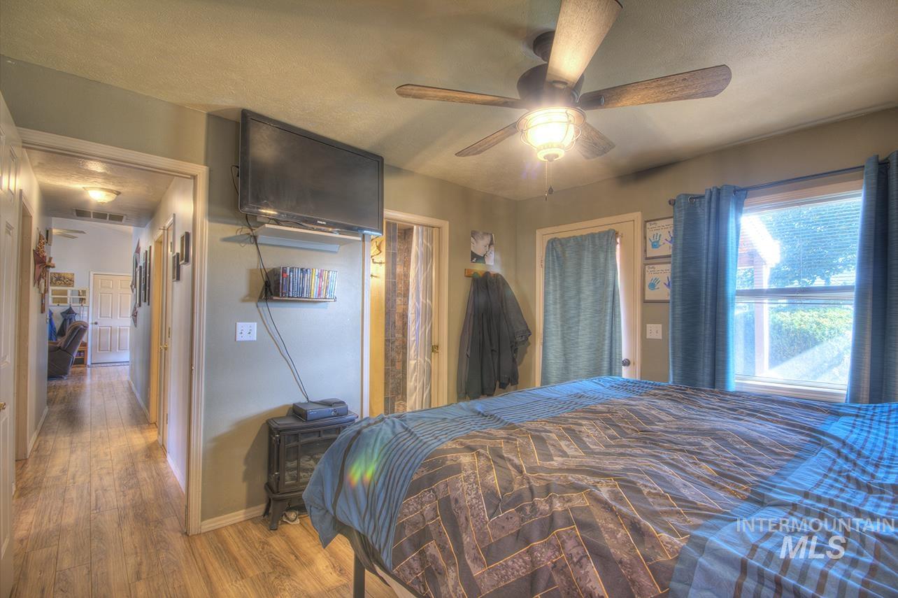 Bedroom featuring wood finished floors, a textured ceiling, and ceiling fan