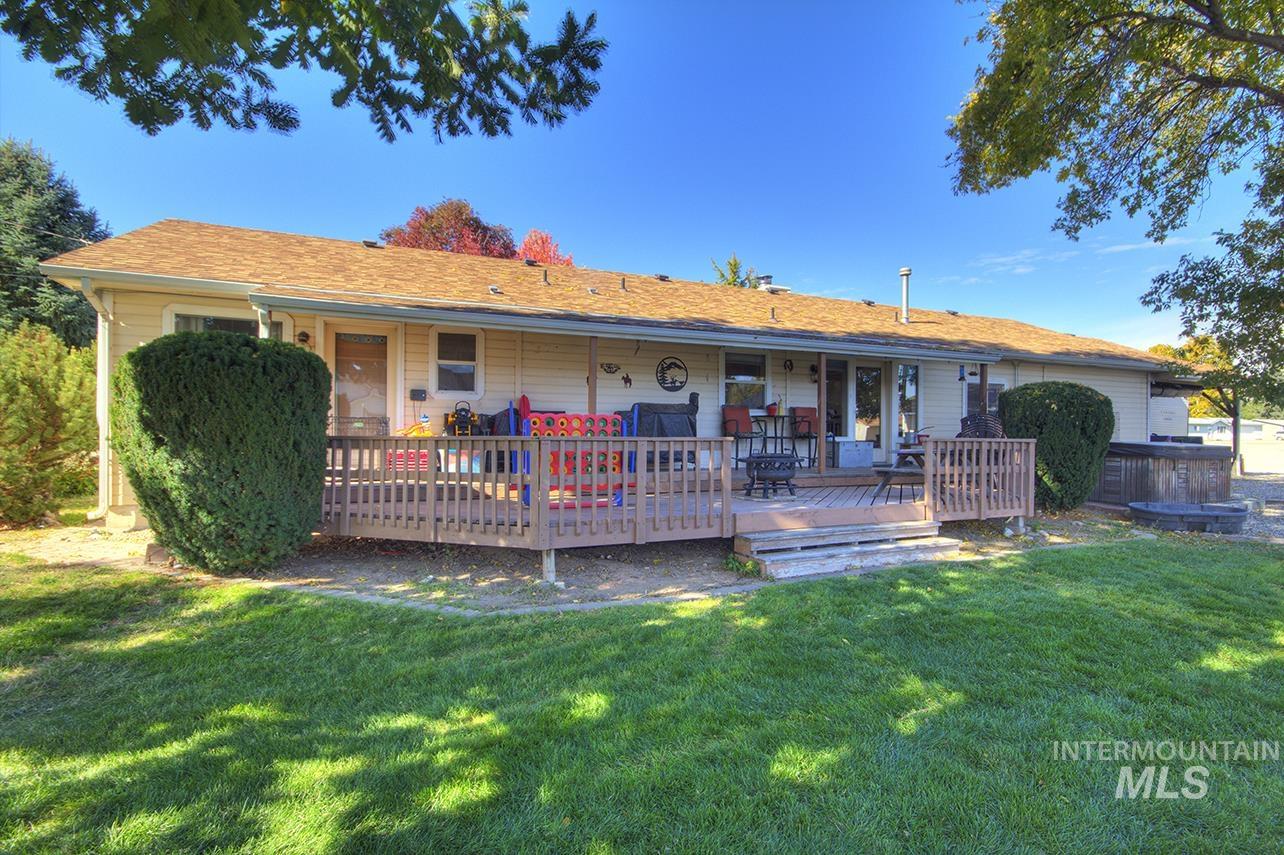 Rear view of house with a deck and a yard