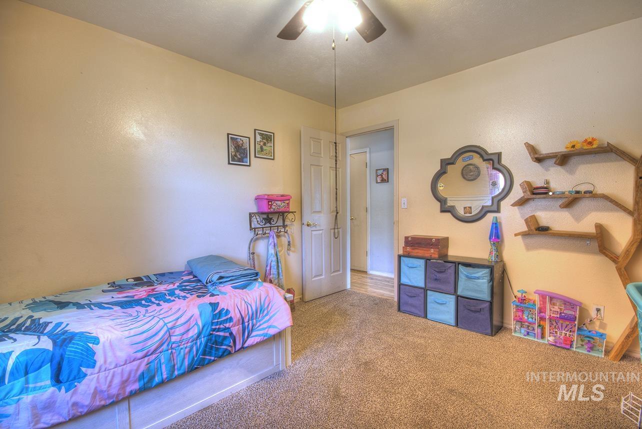 Carpeted bedroom with a ceiling fan